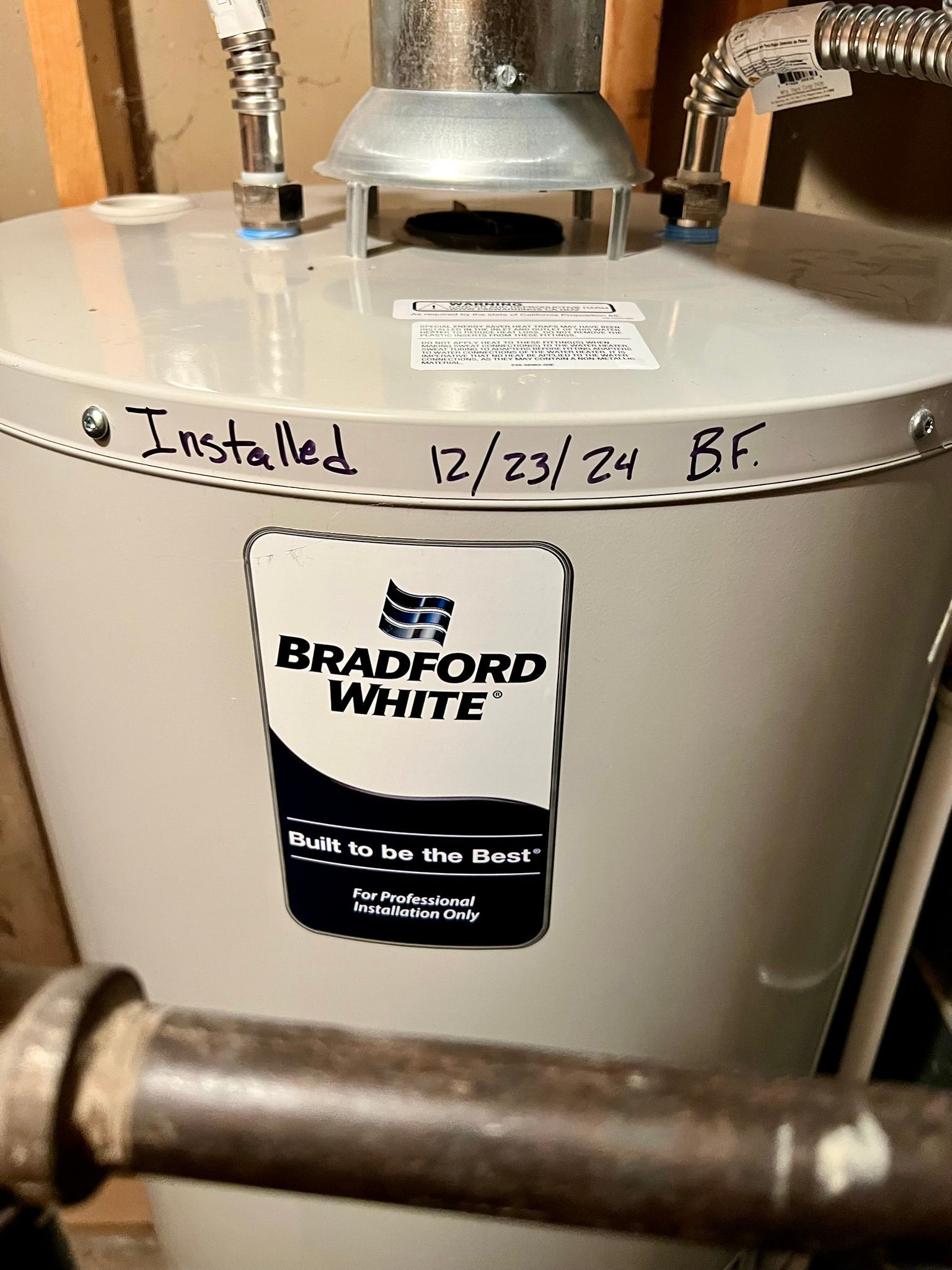 A bradford white water heater is sitting in a basement.