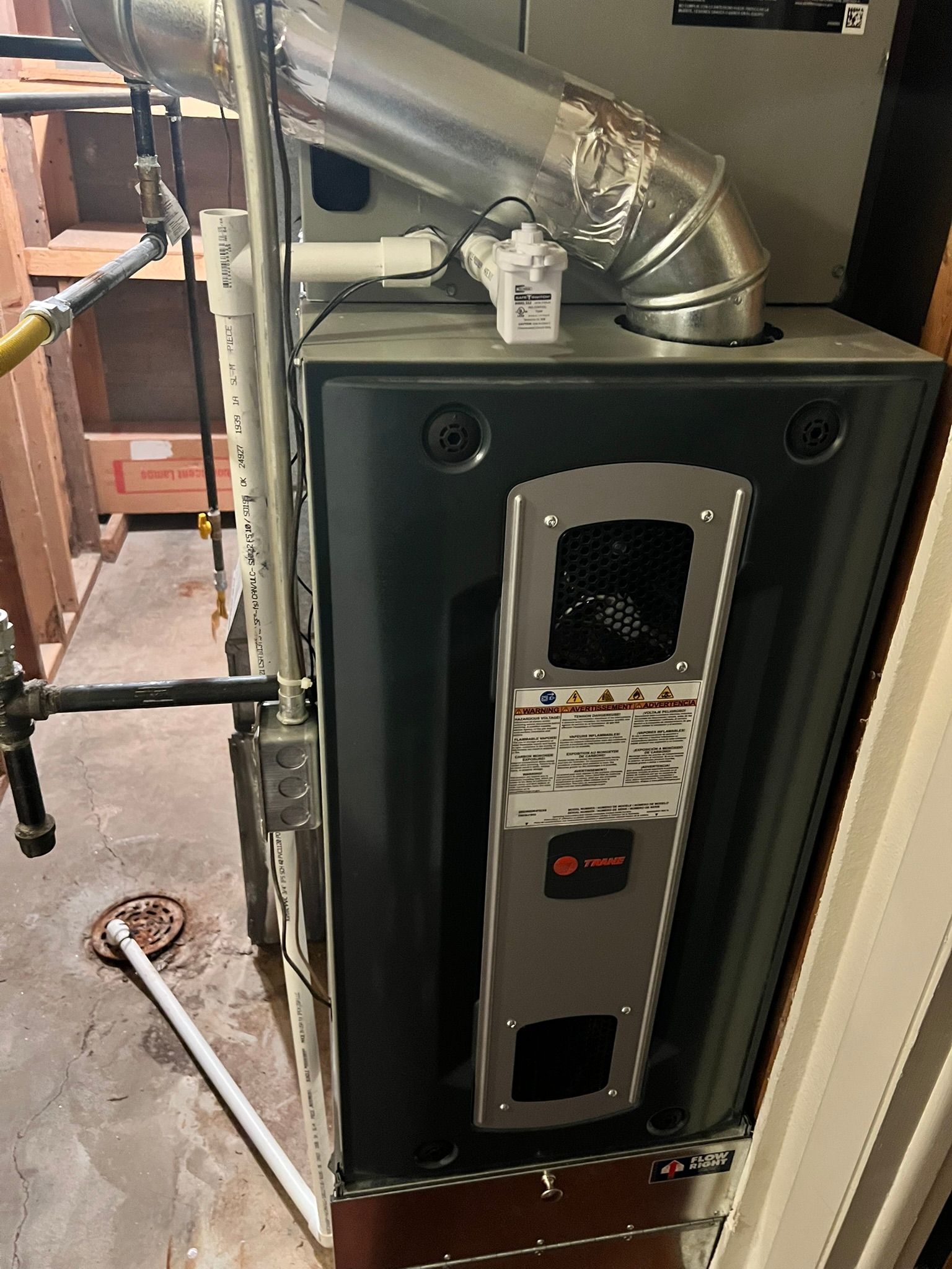 A gas heater is sitting in a room next to a door.