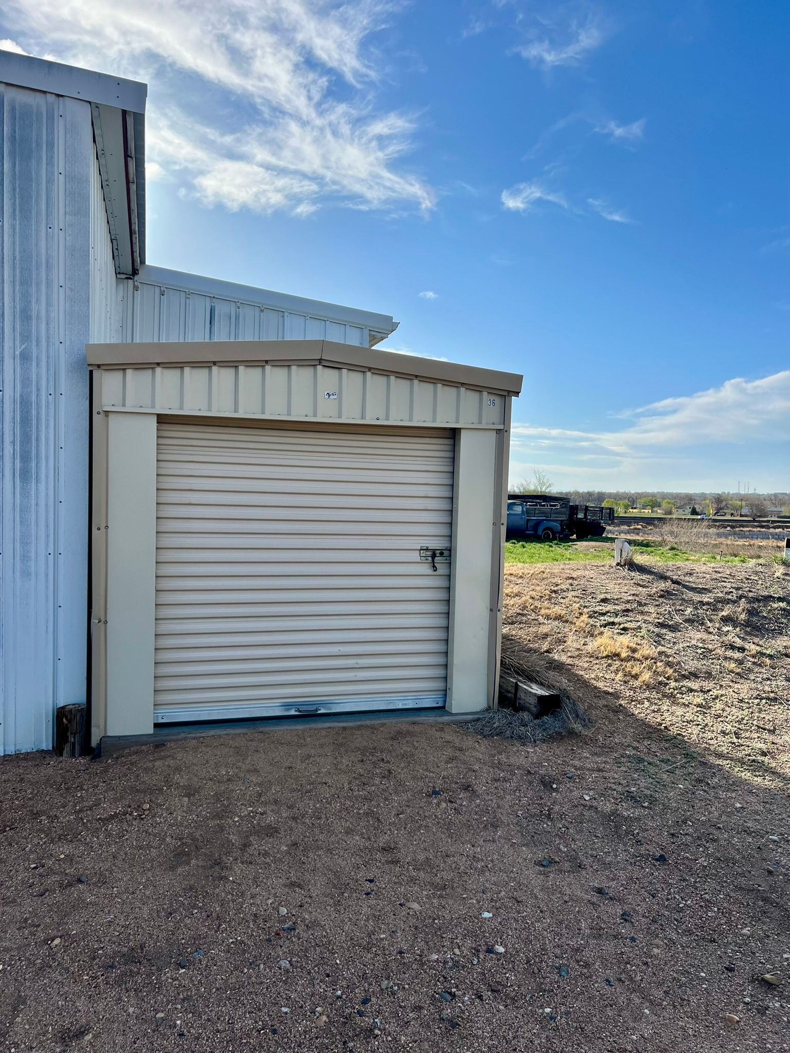 A white garage door is sitting next to a white building.