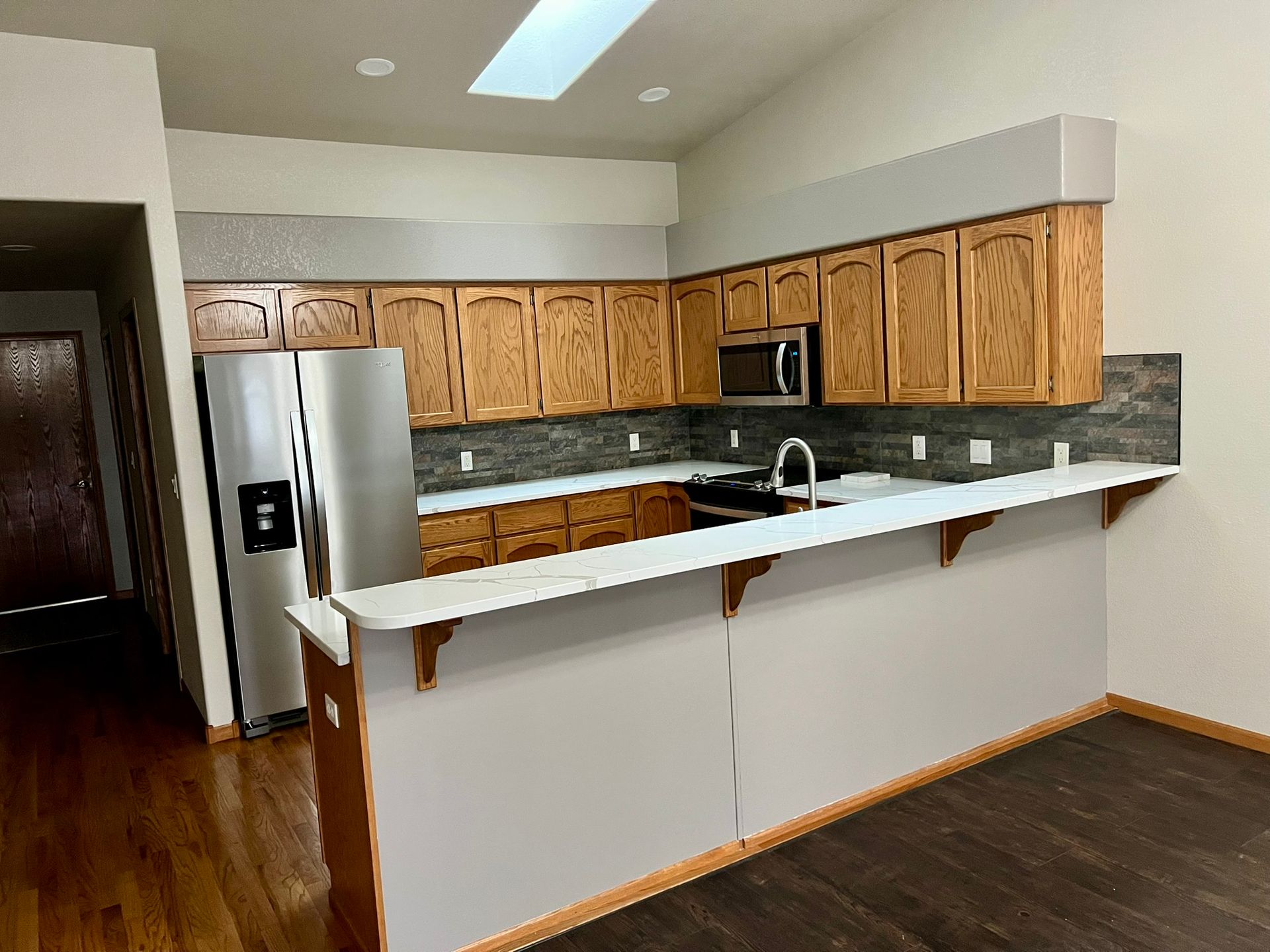A kitchen with stainless steel appliances and wooden cabinets