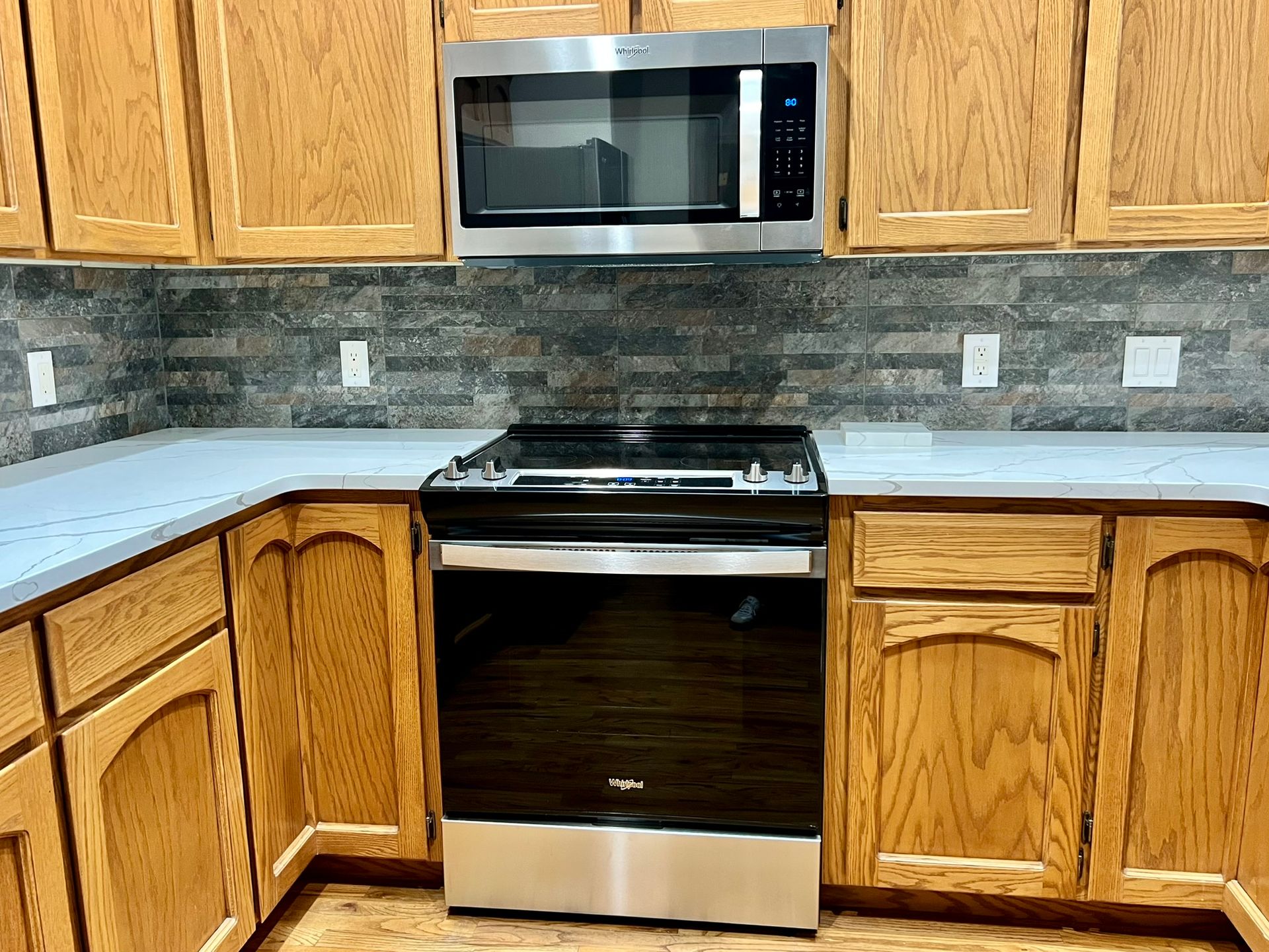 A kitchen with stainless steel appliances and wooden cabinets.