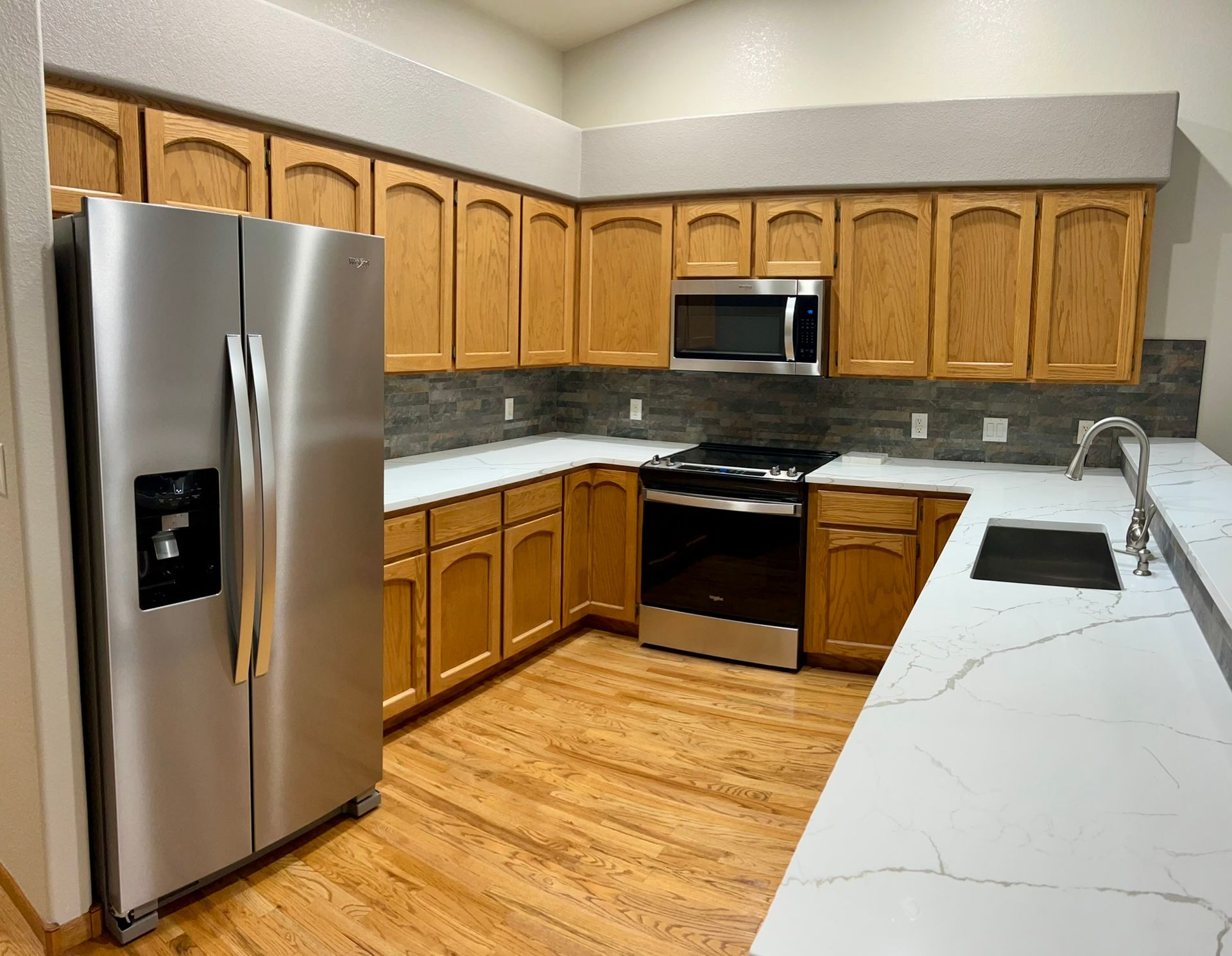 A kitchen with stainless steel appliances and wooden cabinets.