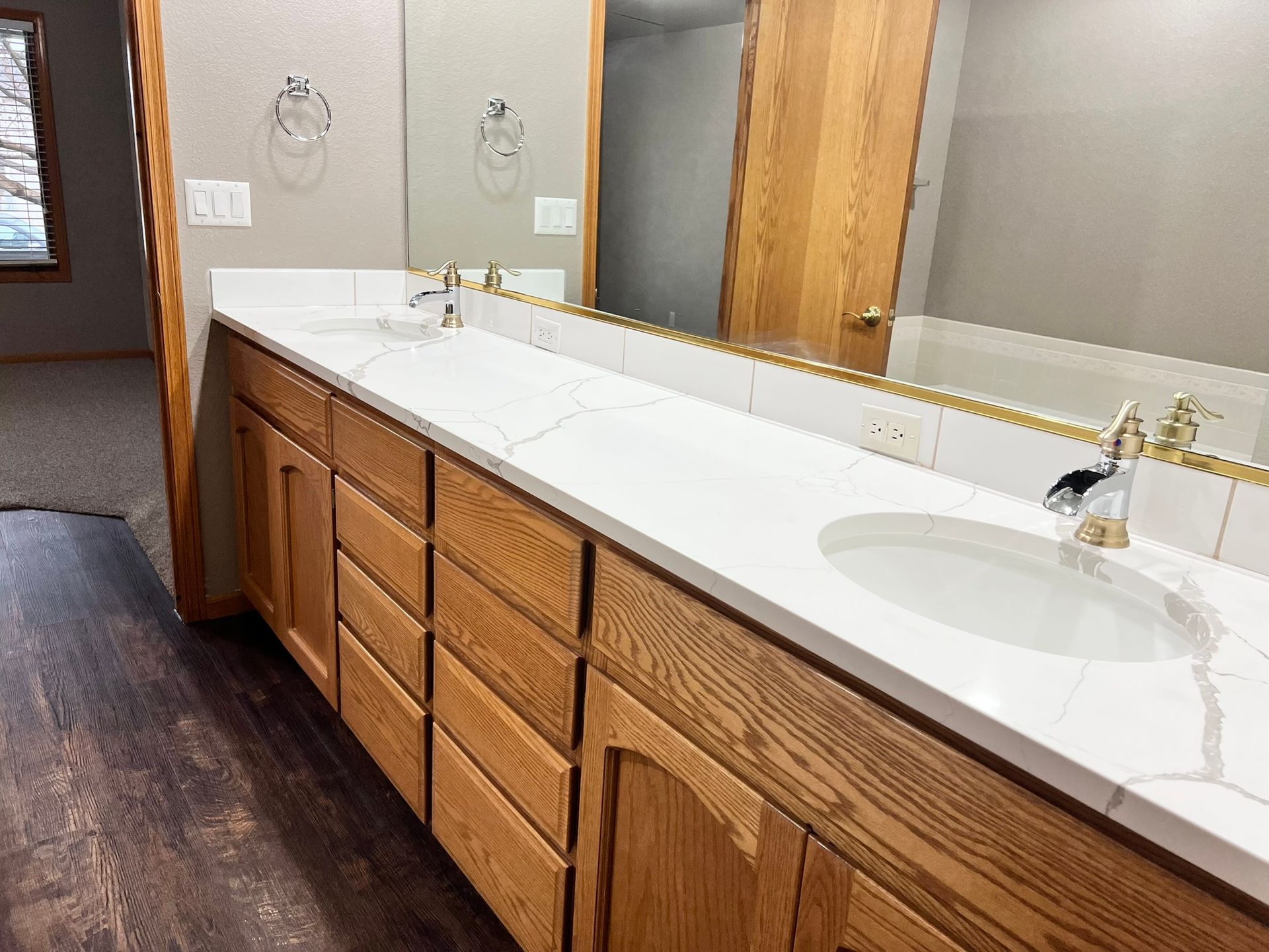 A bathroom with two sinks and a large mirror.