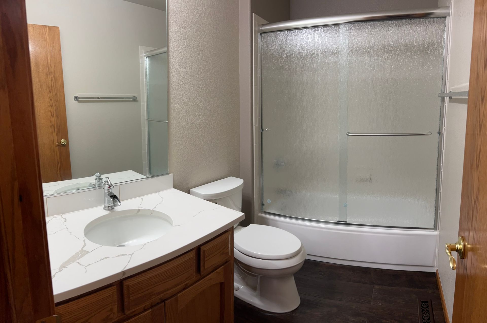 A bathroom with a toilet , sink , and shower.