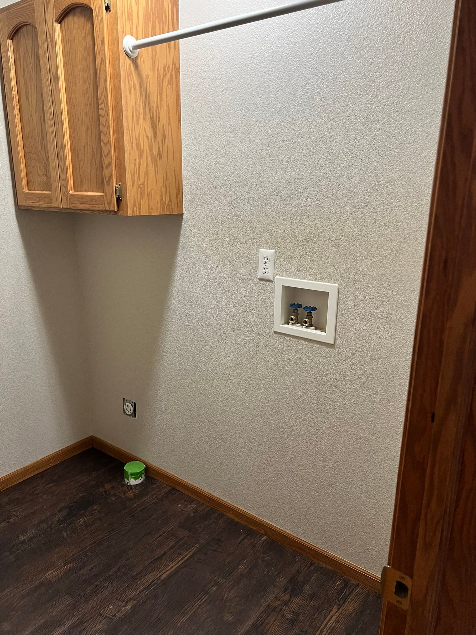 A laundry room with wooden cabinets and a washer and dryer.