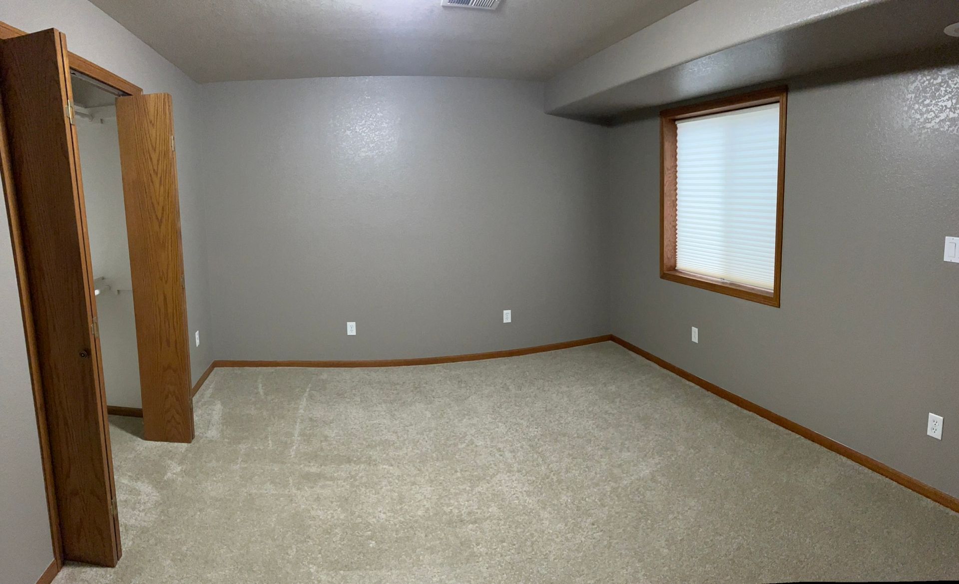 An empty room with a window and a door.