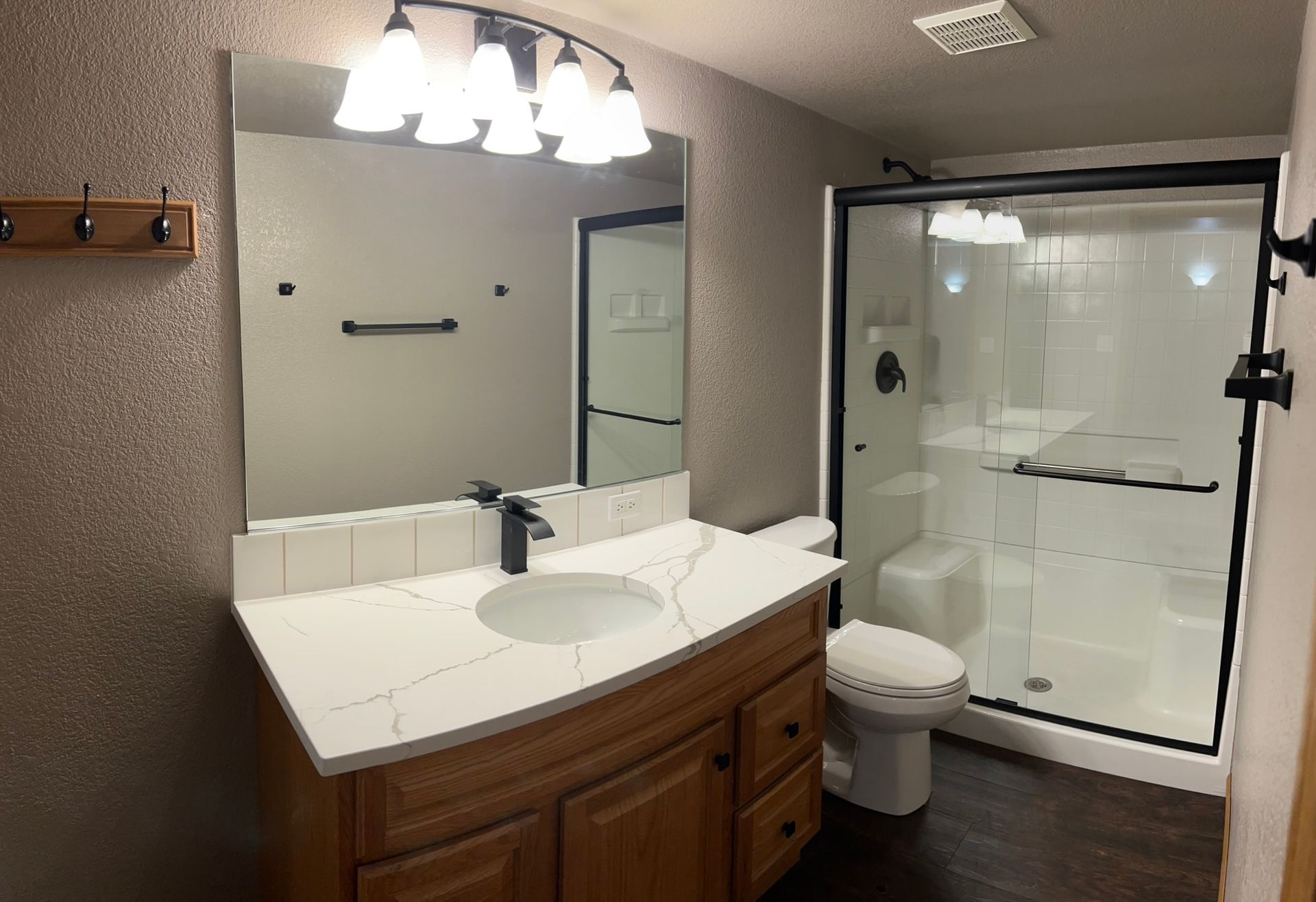 A bathroom with a sink , toilet and shower.