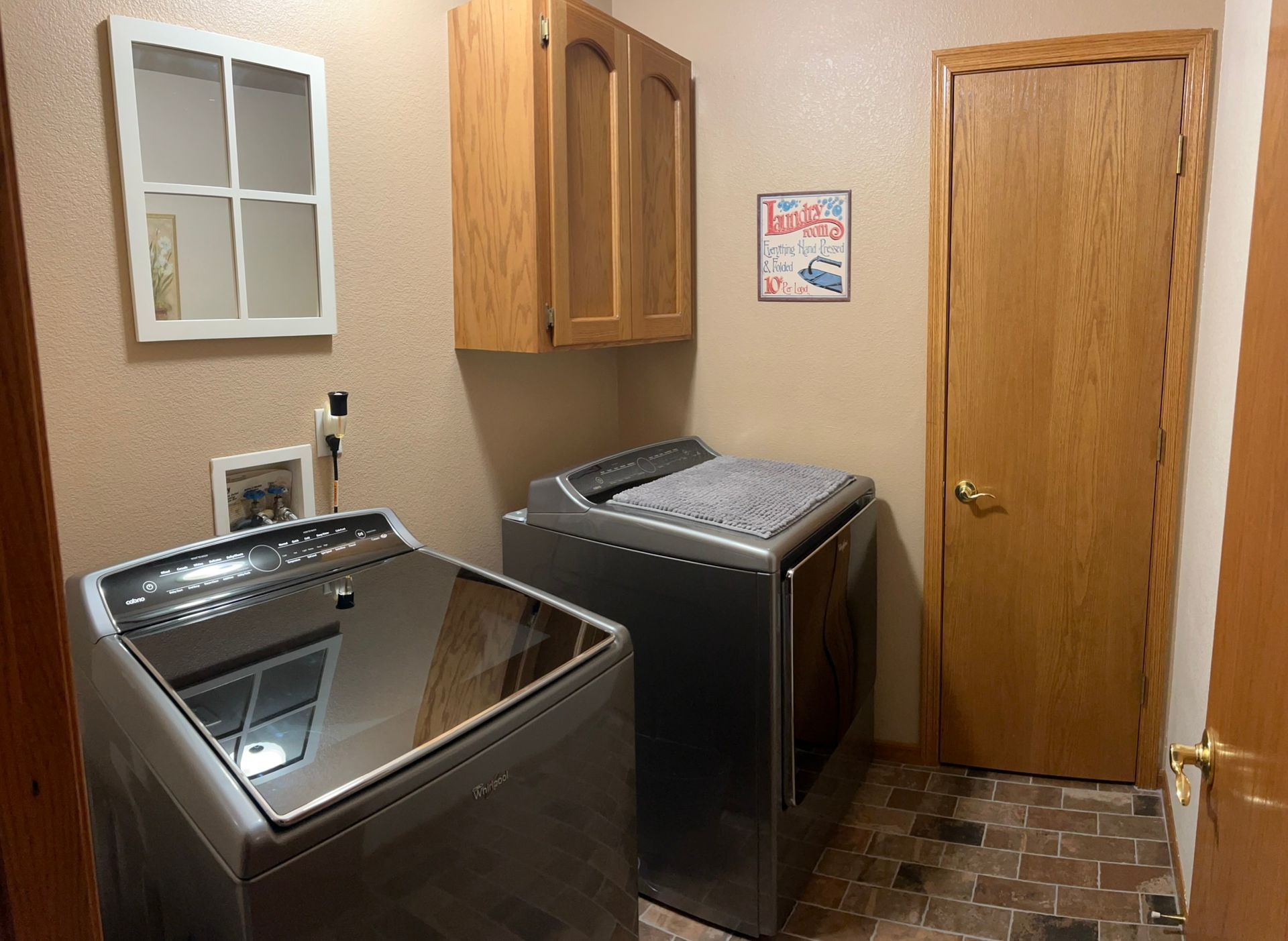 A laundry room with two washing machines and a dryer.