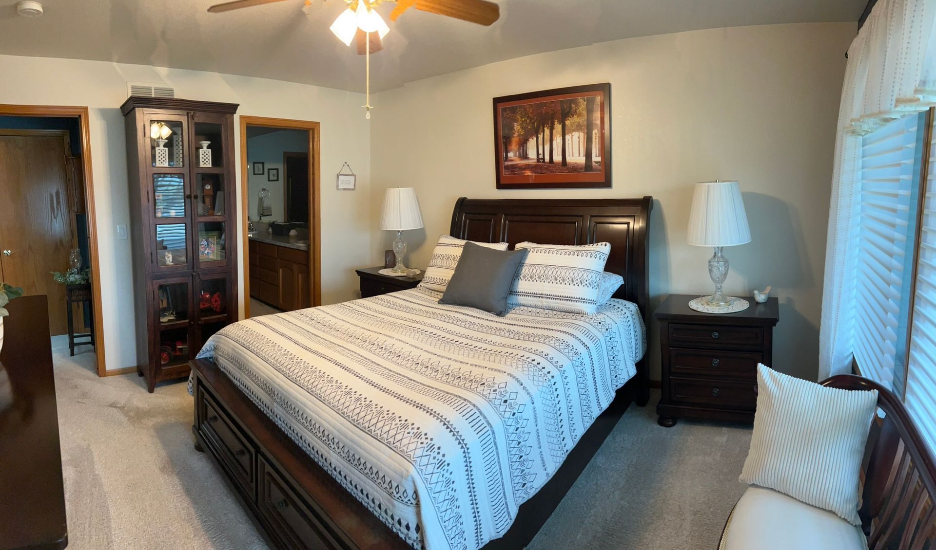A bedroom with a king size bed and a ceiling fan