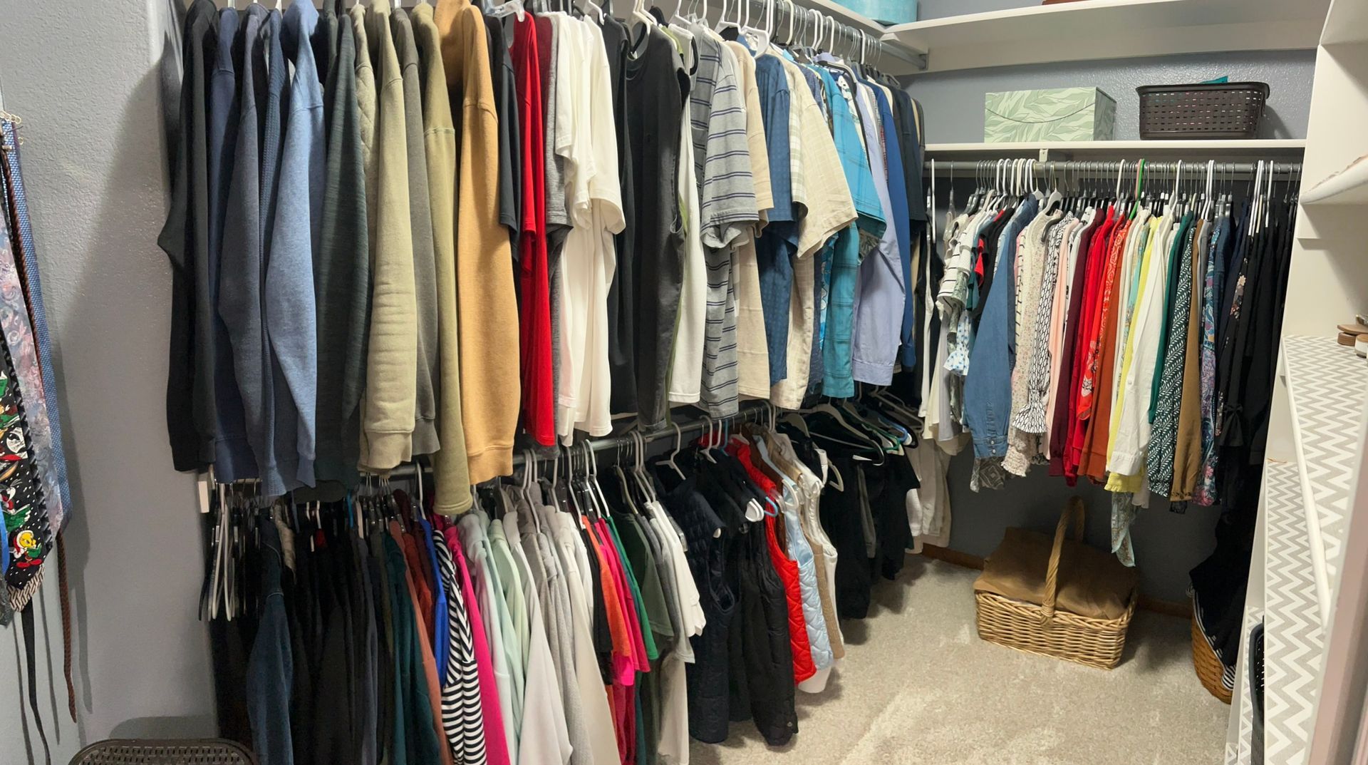 A closet filled with lots of clothes and a basket.