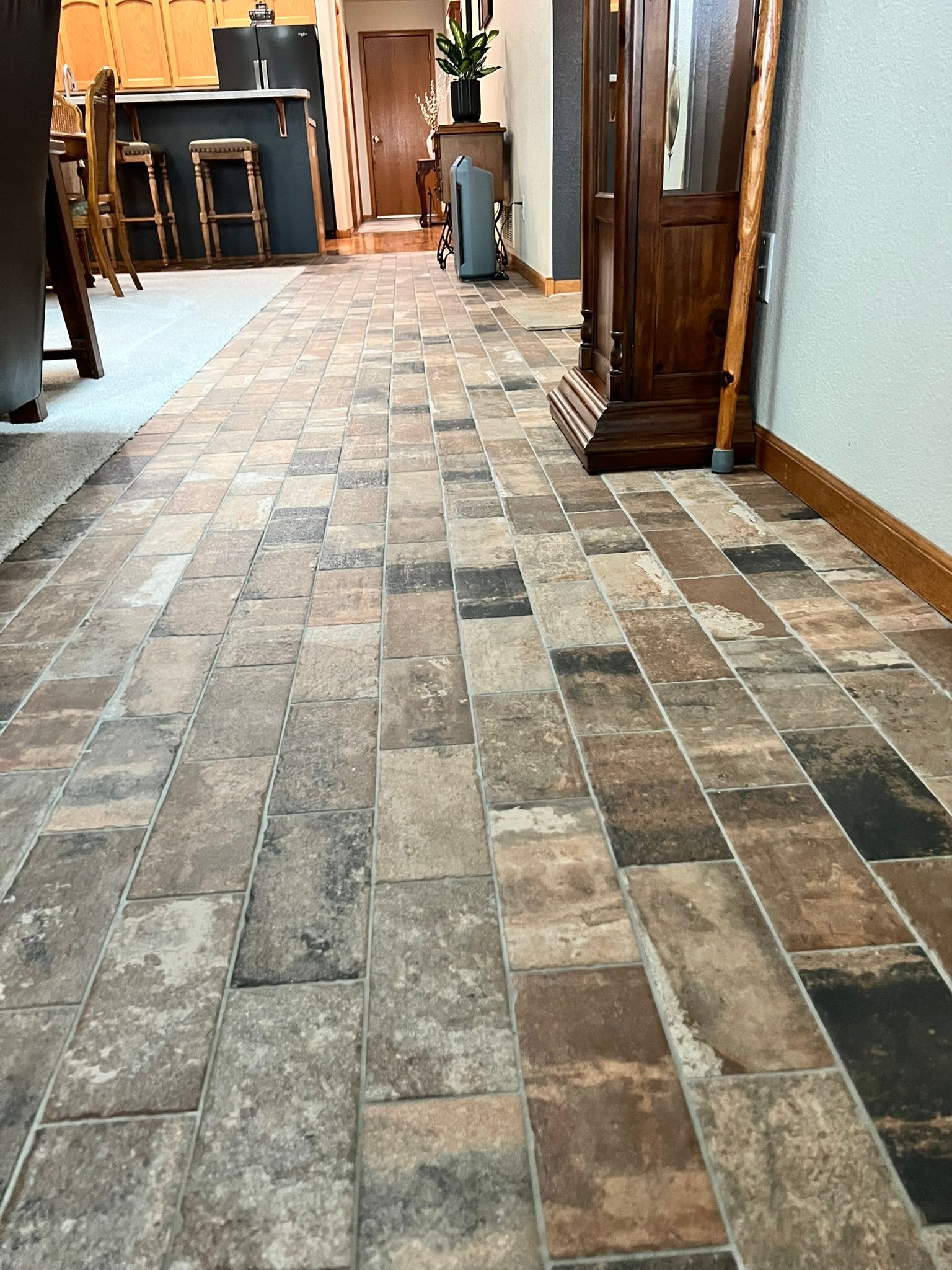 A hallway with a tiled floor and a clock on the wall.