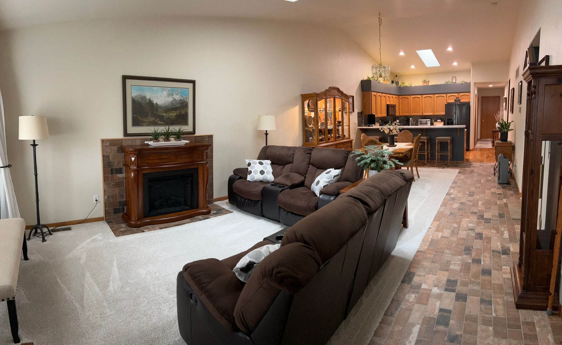 A living room with brown furniture and a fireplace