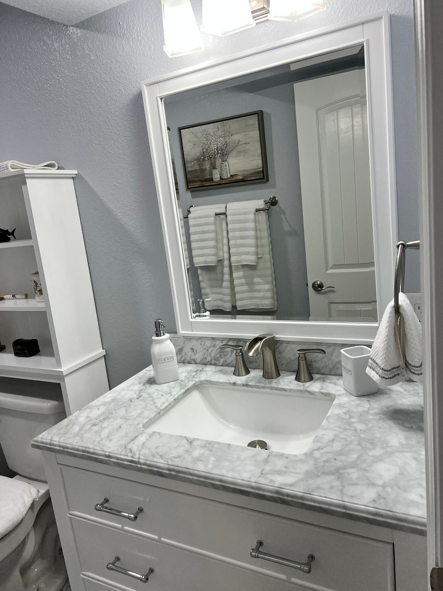 A bathroom with a sink , mirror and toilet.