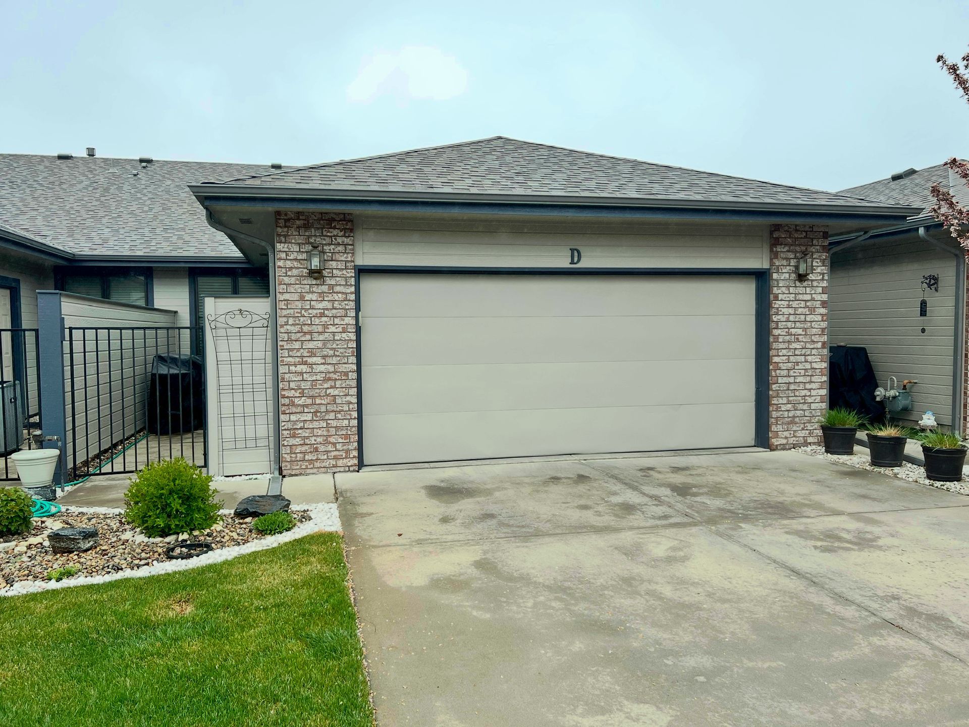 A house with a garage door and a brick wall