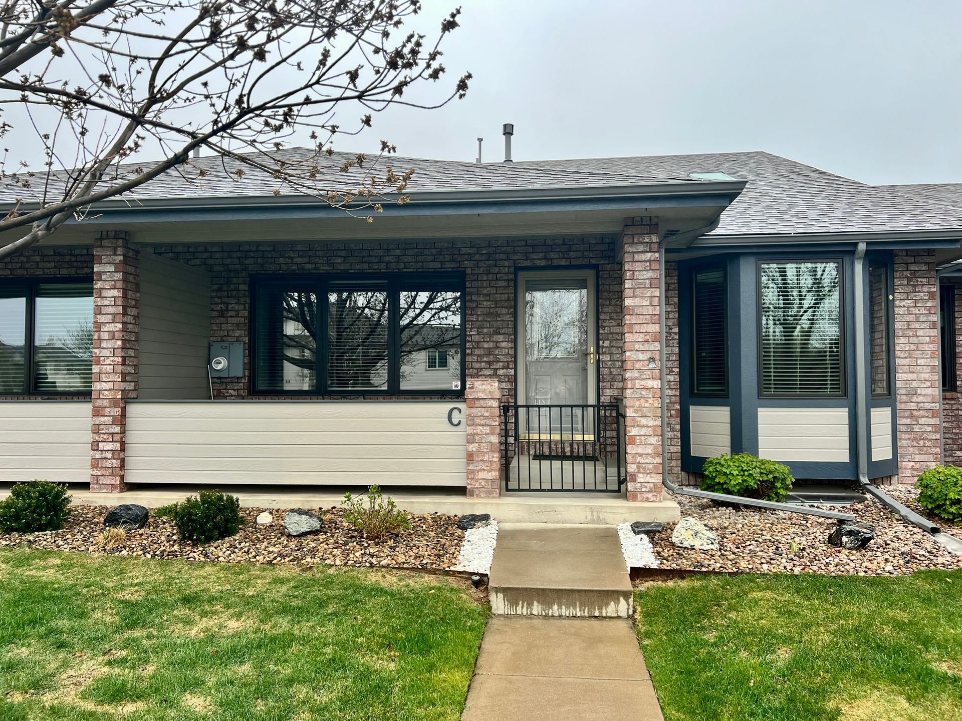 A brick house with a porch and a walkway leading to it