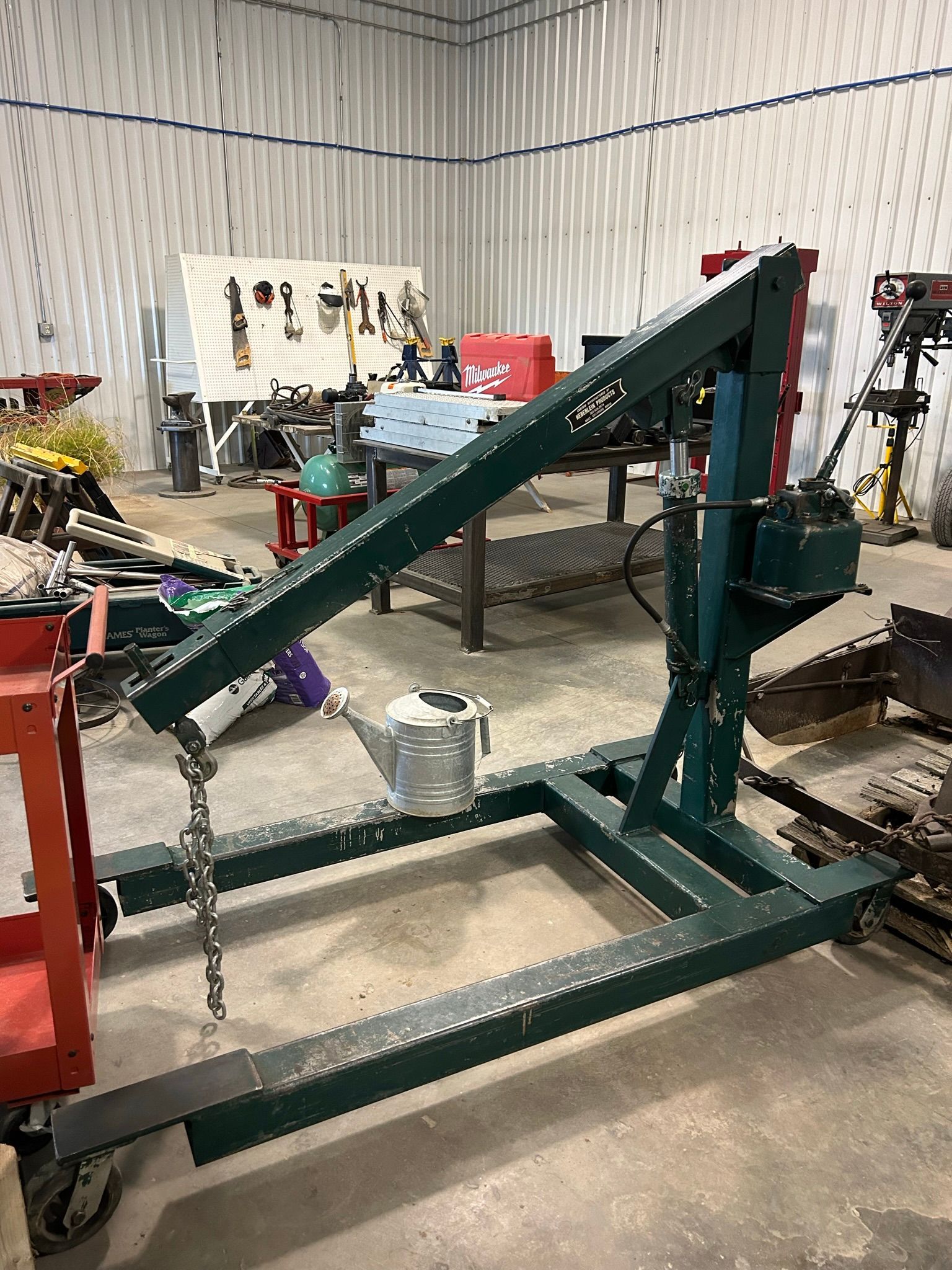 A crane is sitting in a garage next to a table.