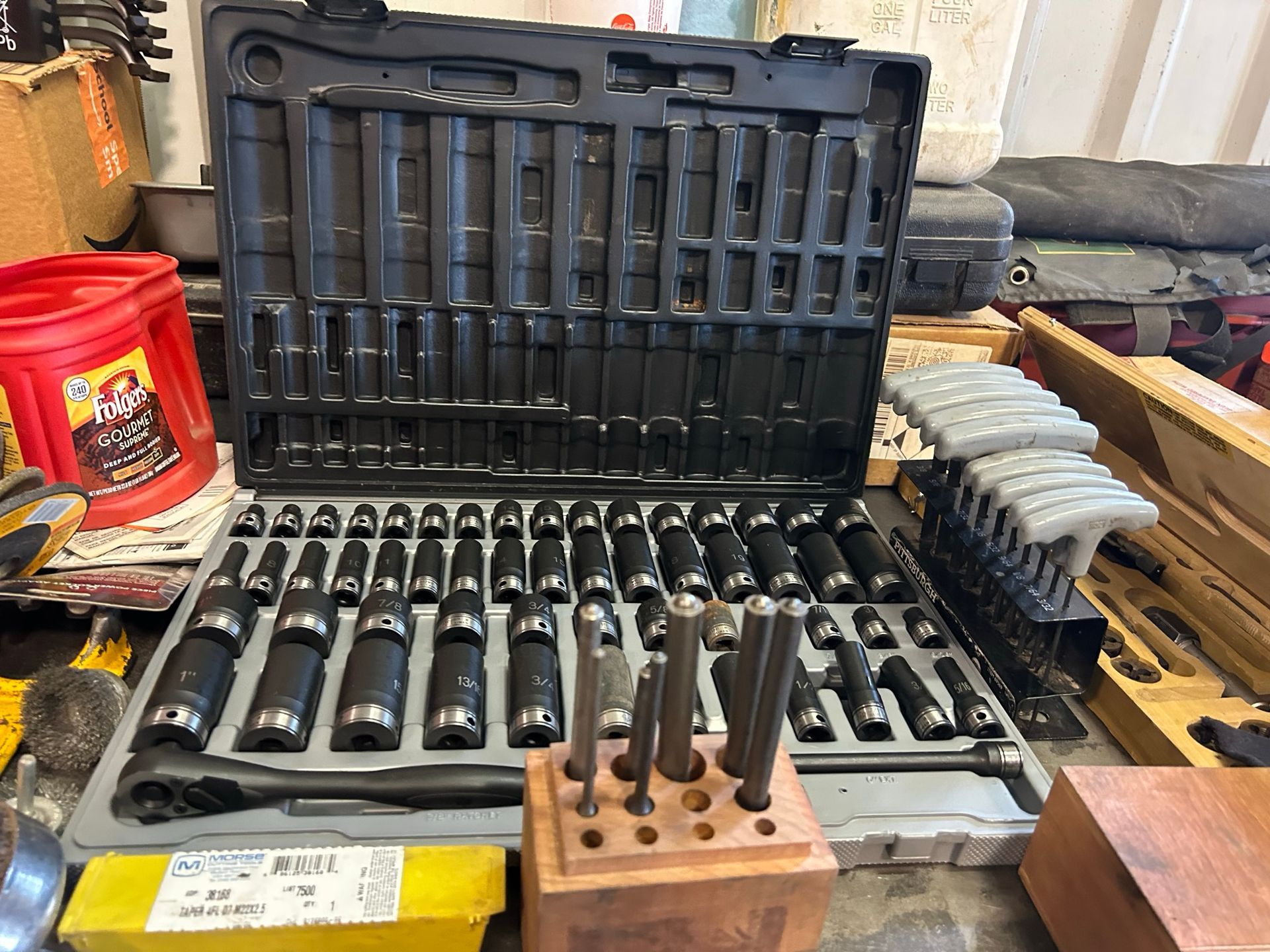 A box of tools is sitting on top of a wooden table.