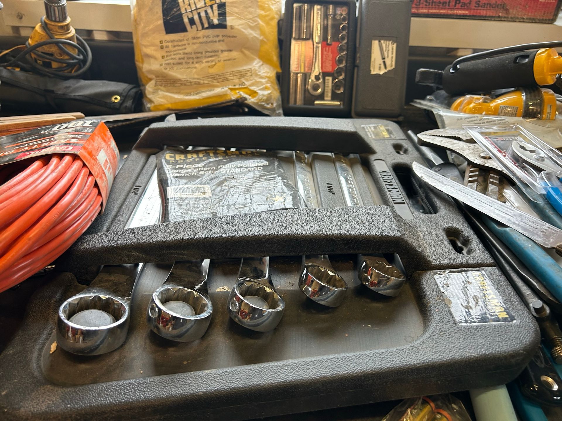 A bunch of tools are sitting on a table including a toolbox
