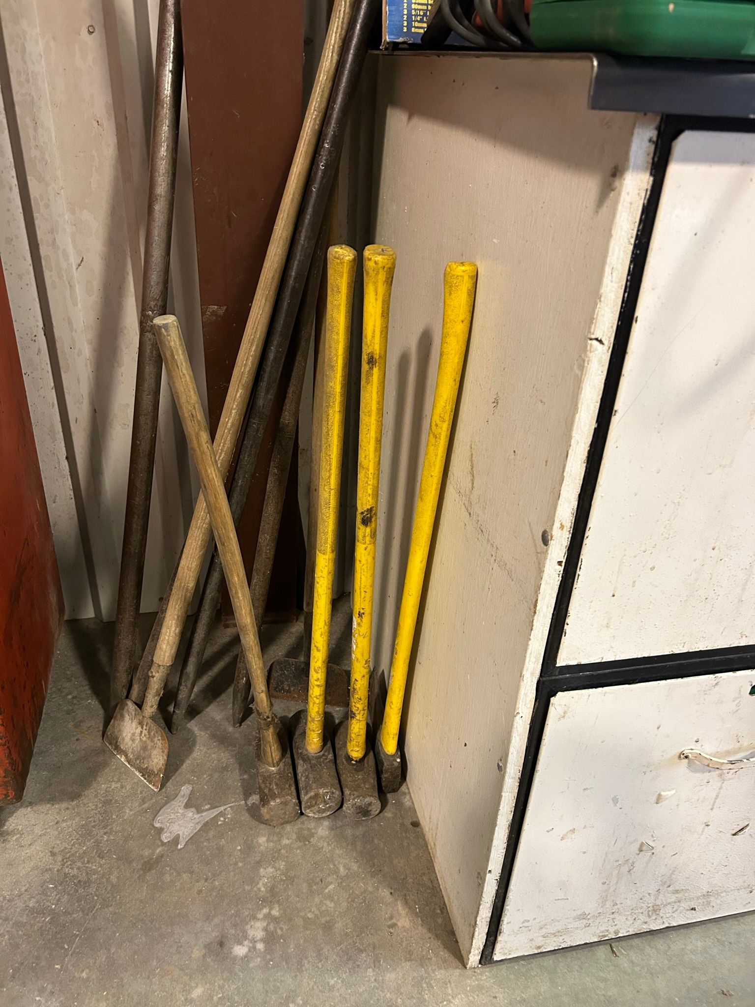 A bunch of tools are sitting on the floor next to a table.