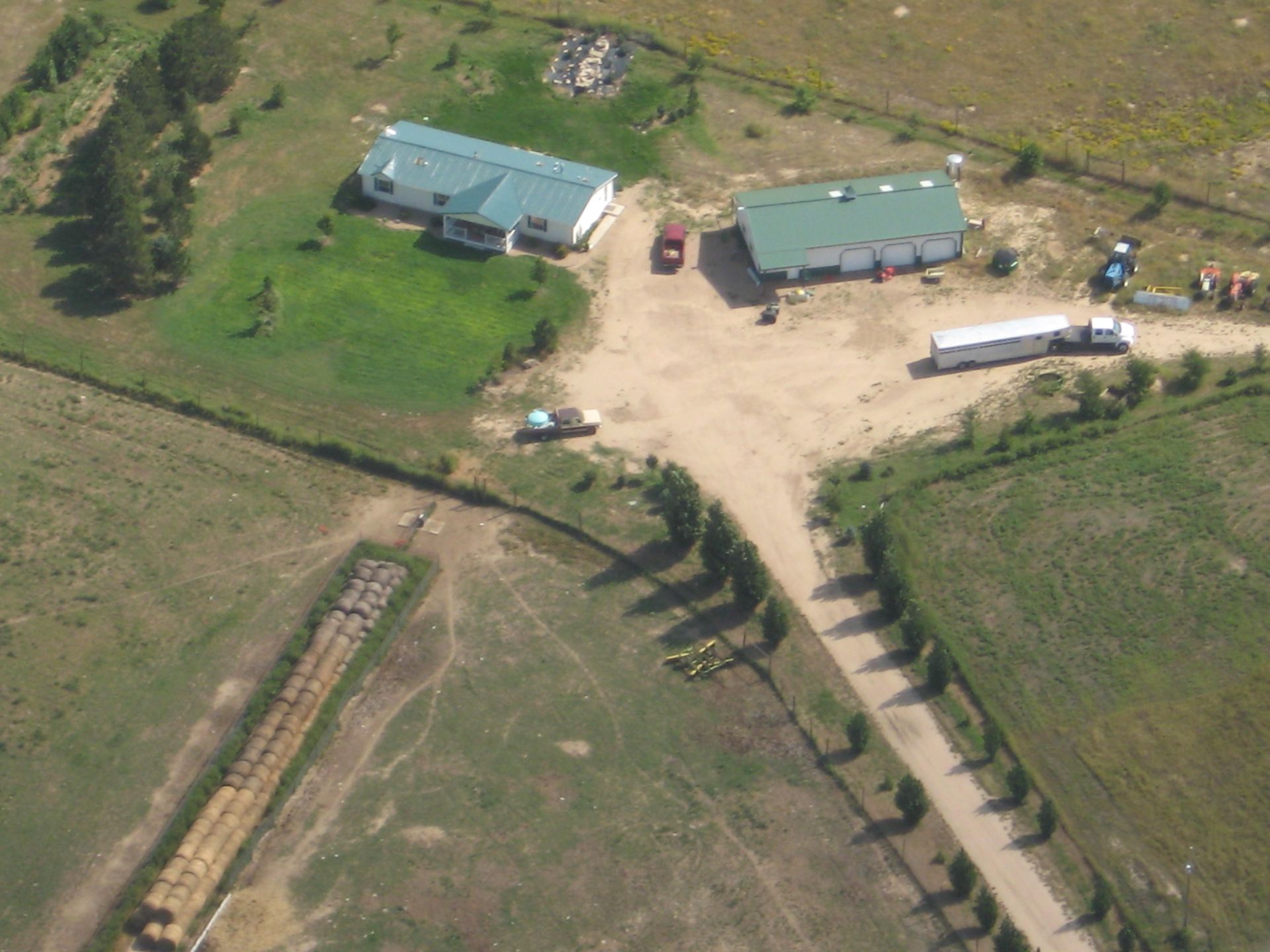 An aerial view of a farm with a green roof