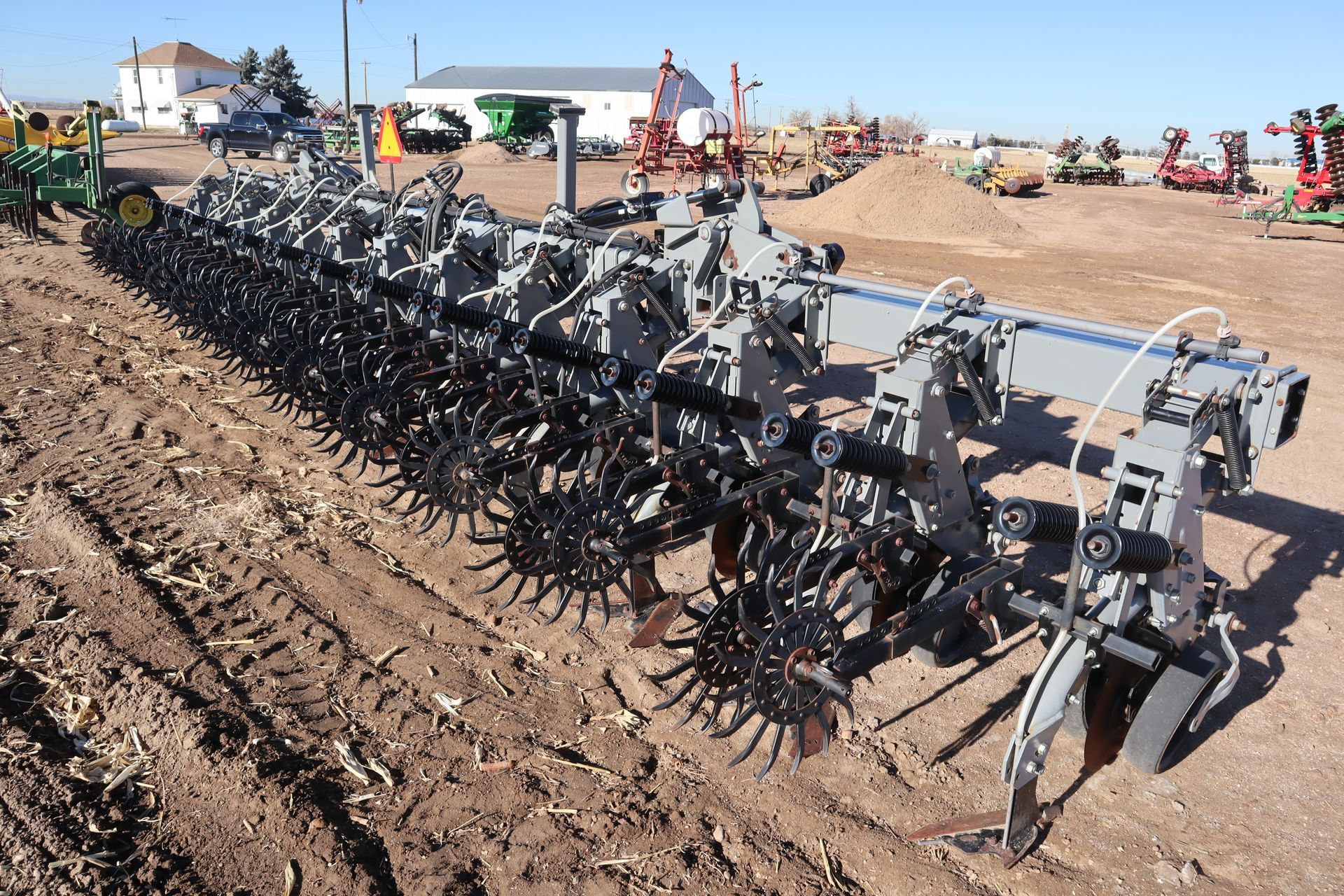 A large machine is sitting in the middle of a dirt field.
