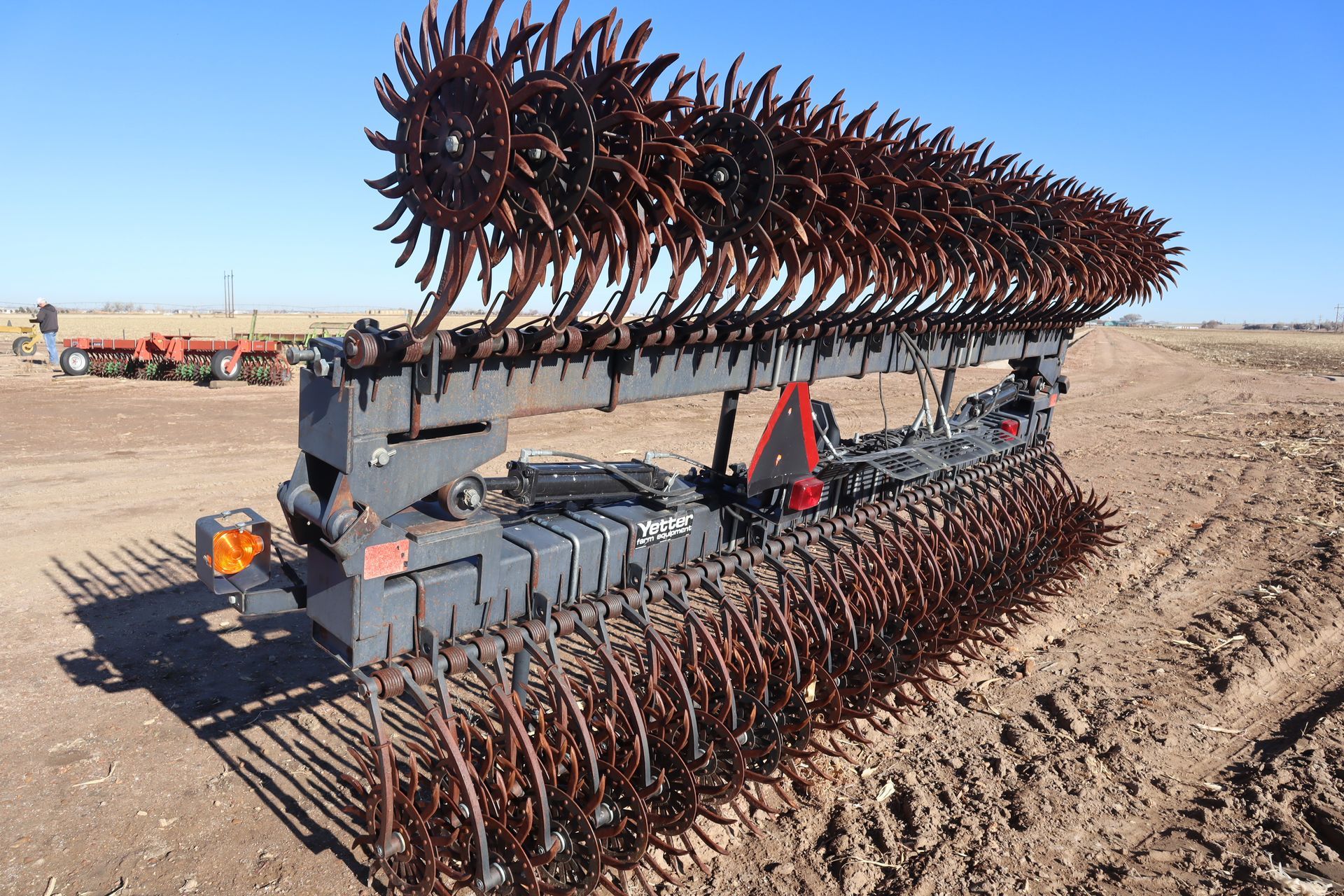 A large machine is sitting in the middle of a dirt field.