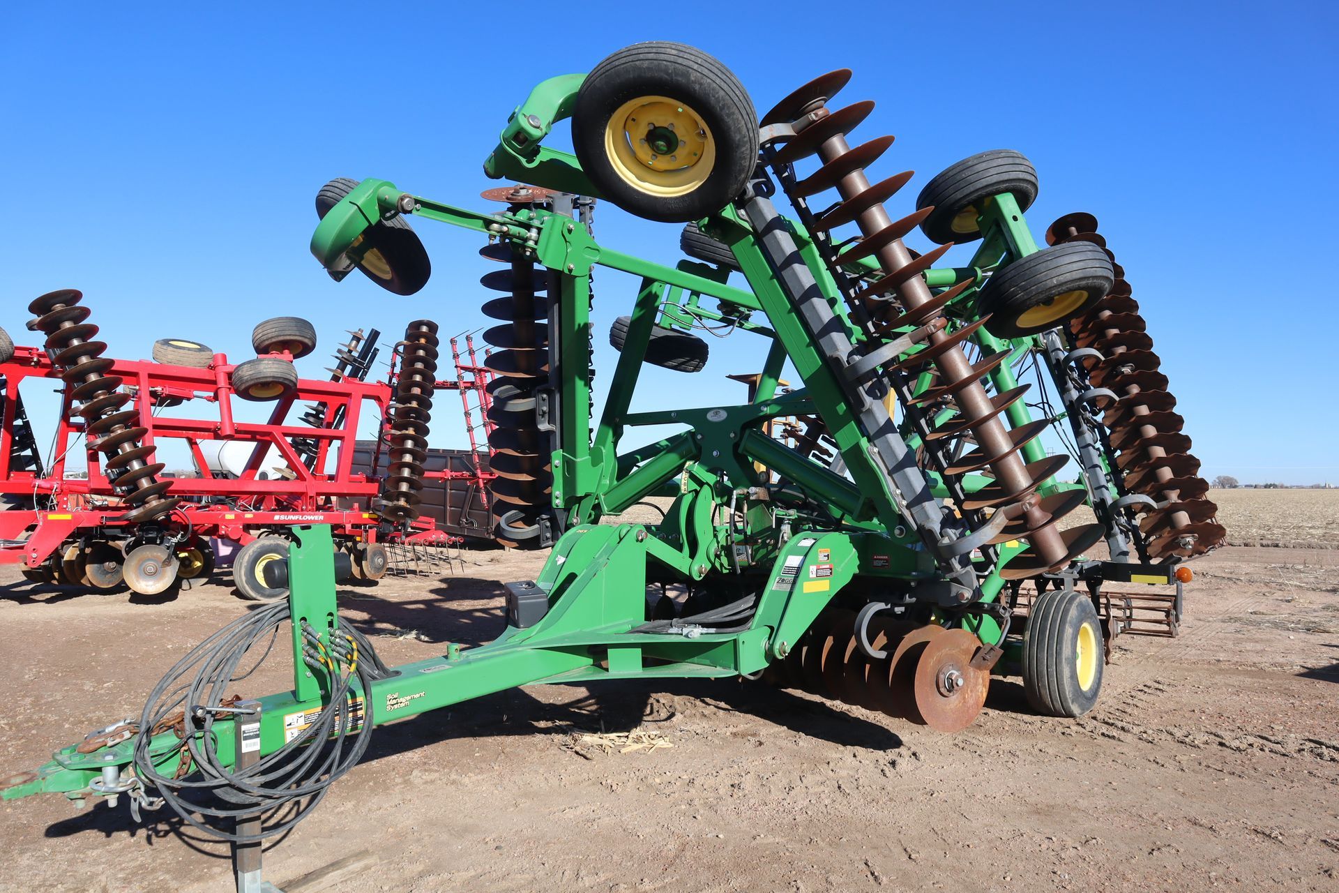 A john deere tractor is parked in a dirt field