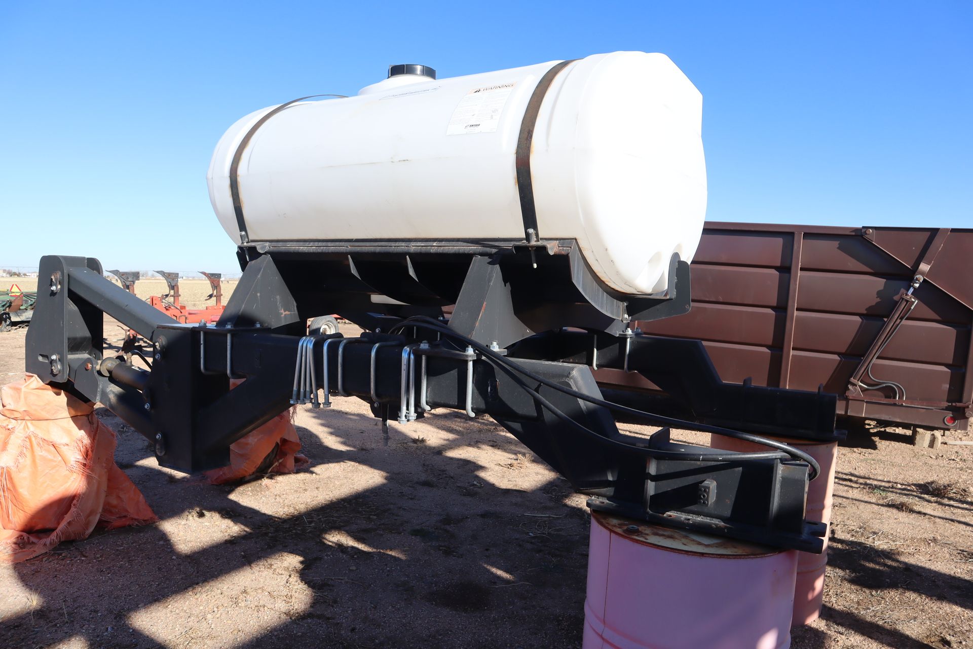 A large white tank is sitting on top of a pink barrel