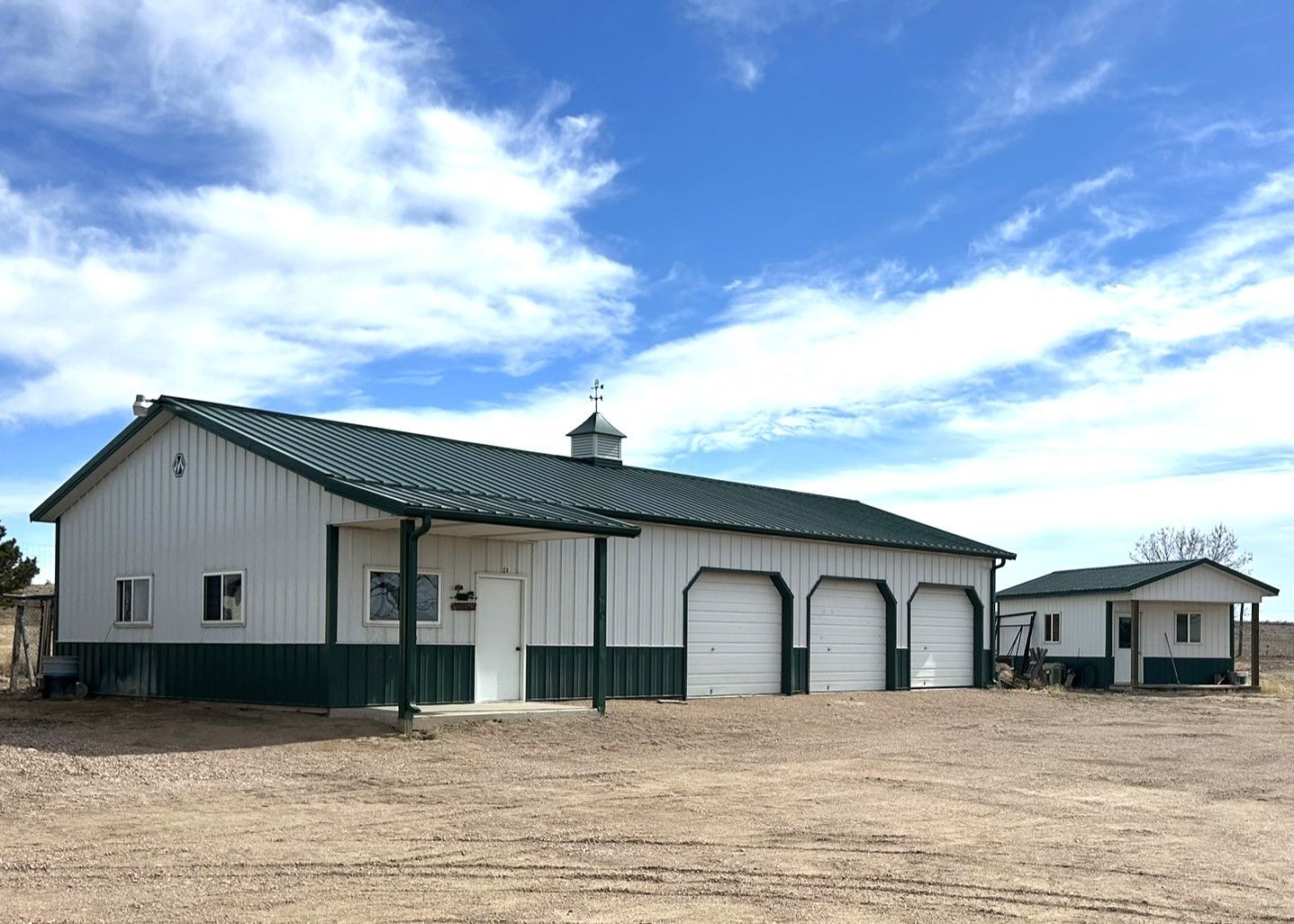 A white and green building with a green roof