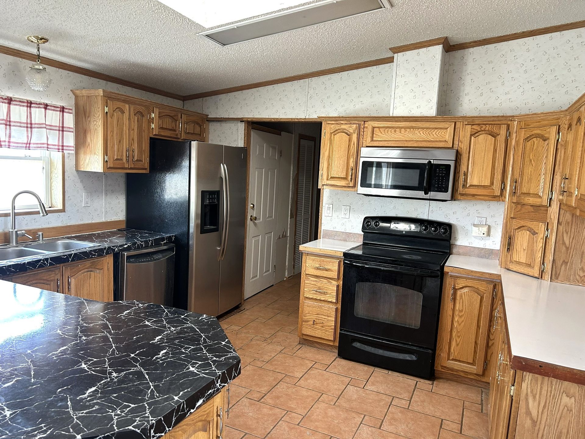 A kitchen with stainless steel appliances and wooden cabinets