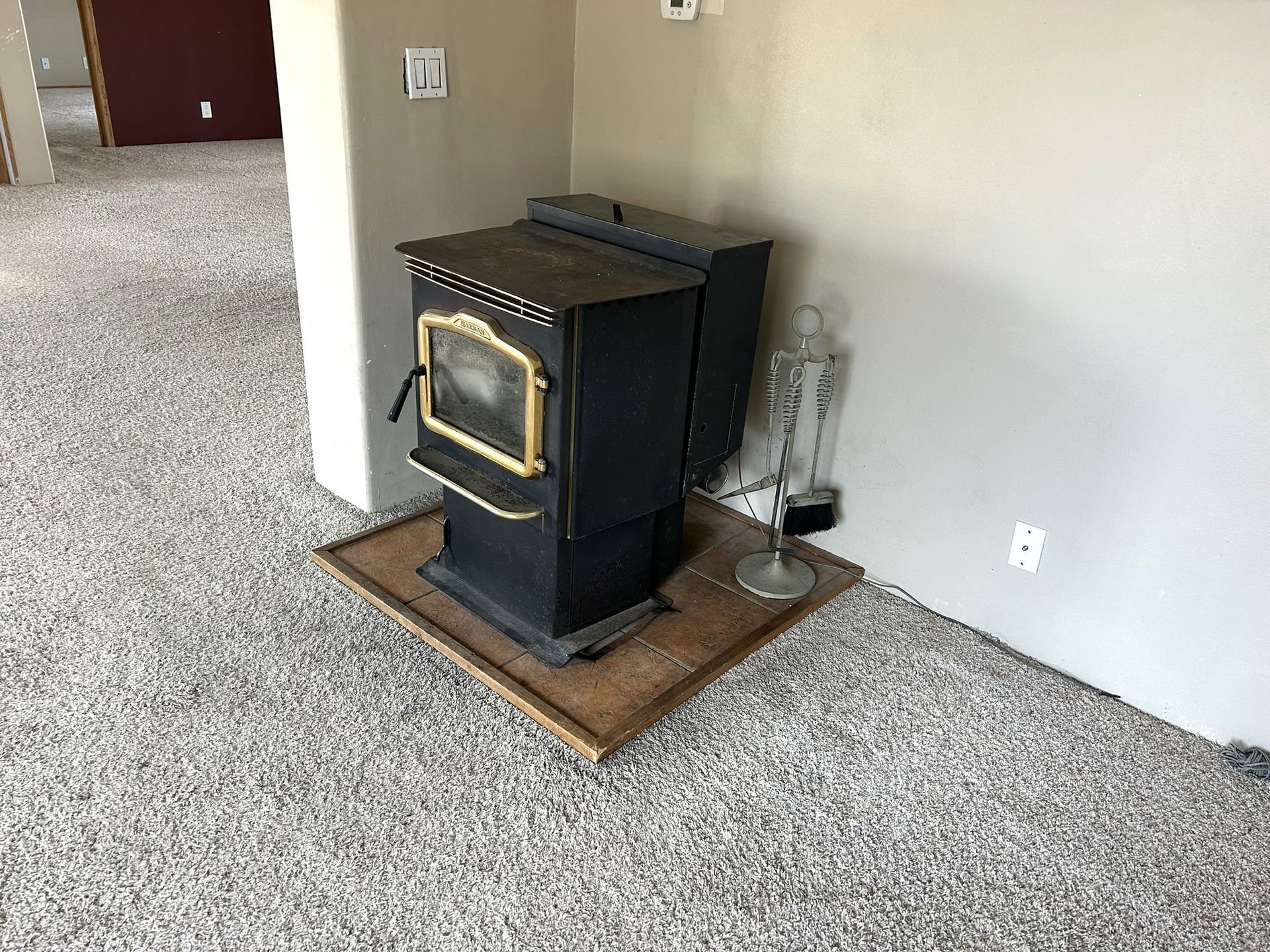 A wood stove is sitting on a carpeted floor in a room.