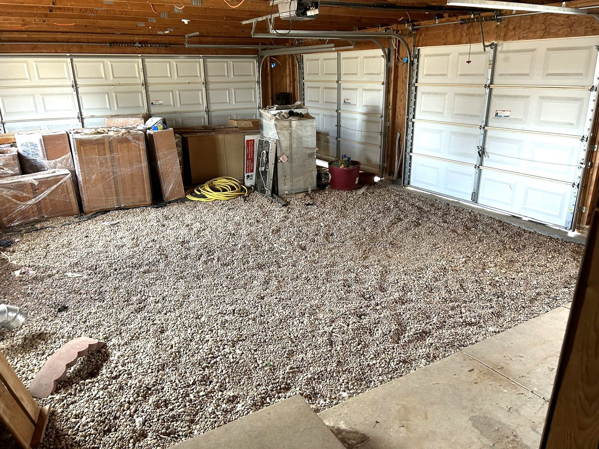 A garage with a lot of wood chips on the floor.