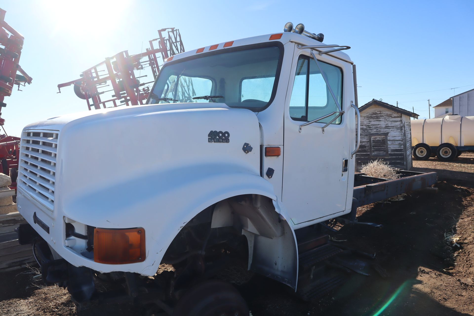 A white truck is parked in a dirt field.