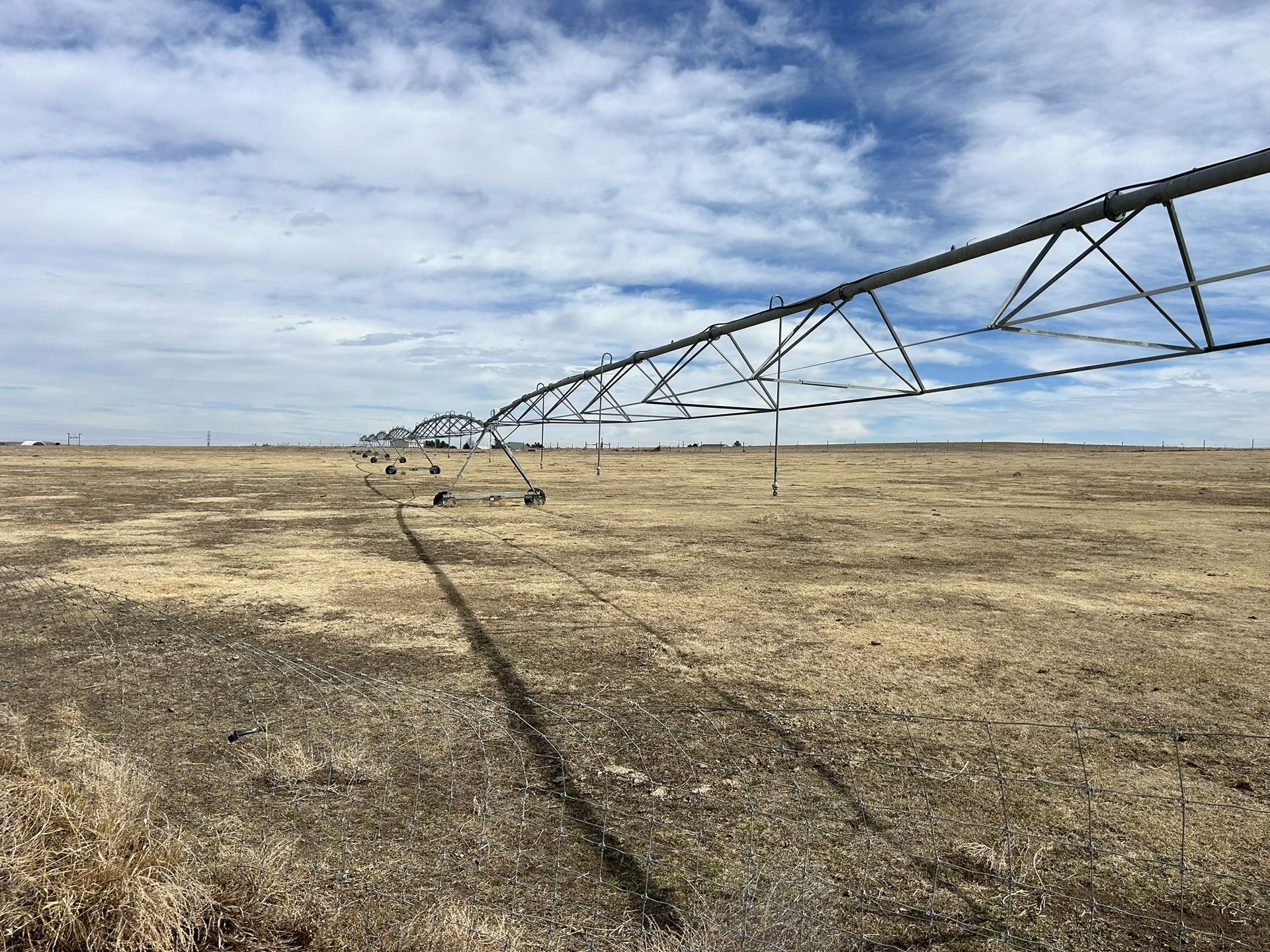 A large irrigation system is in the middle of a dry field.