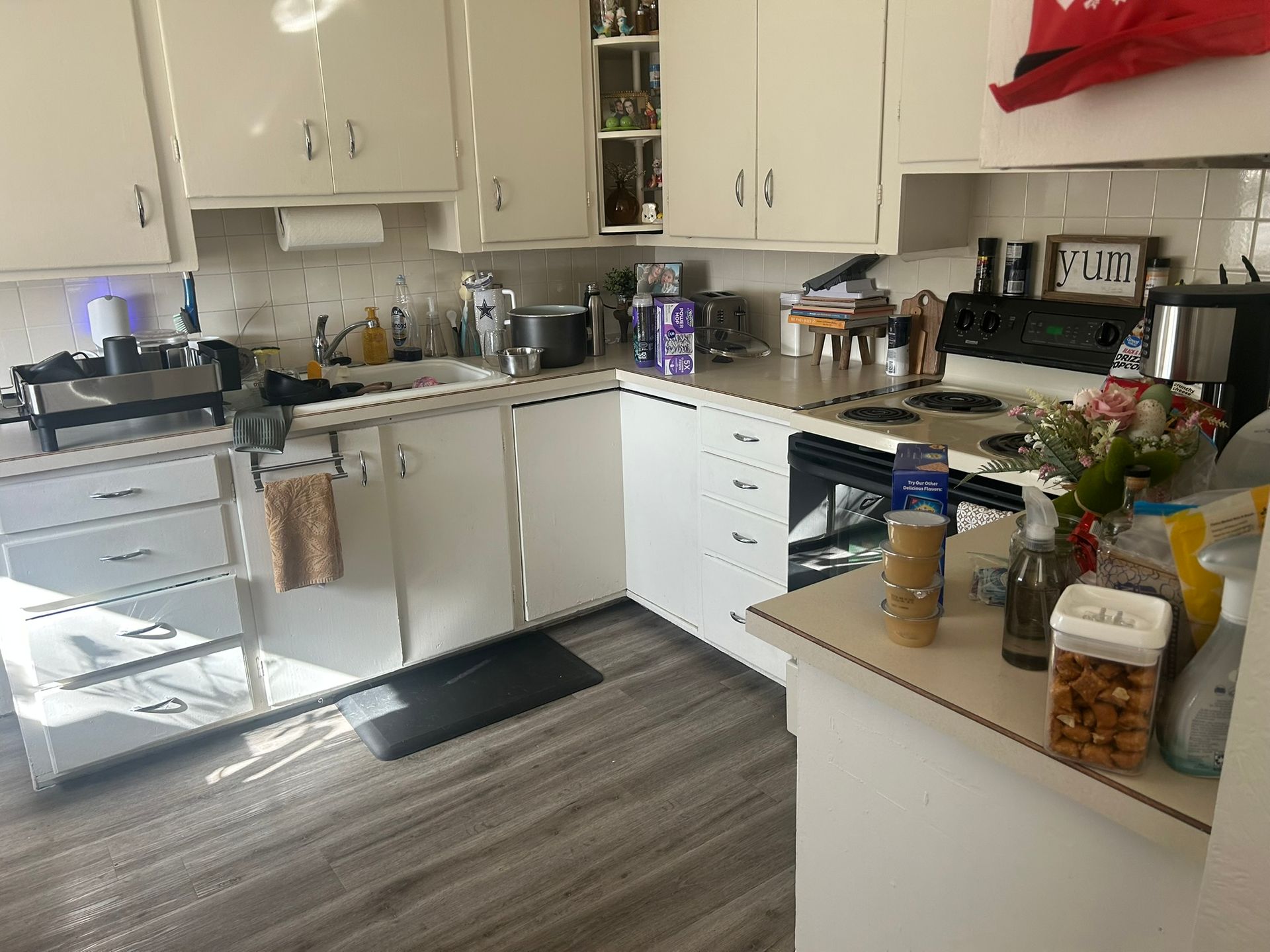 A kitchen with white cabinets and a stove top oven