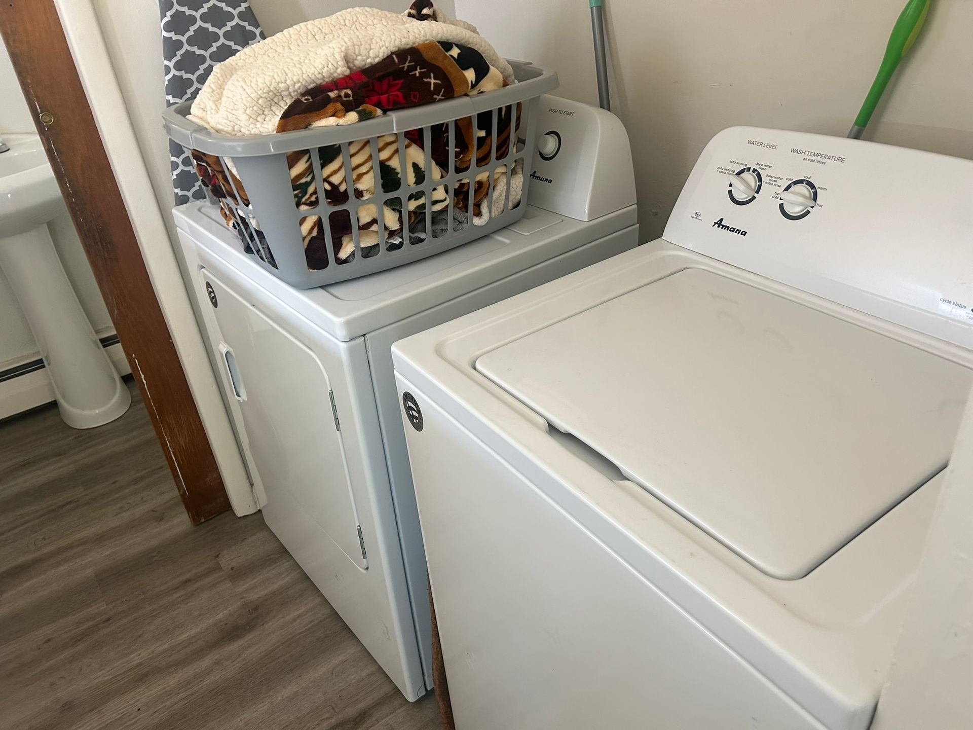 A laundry room with a washer and dryer and a basket of clothes.