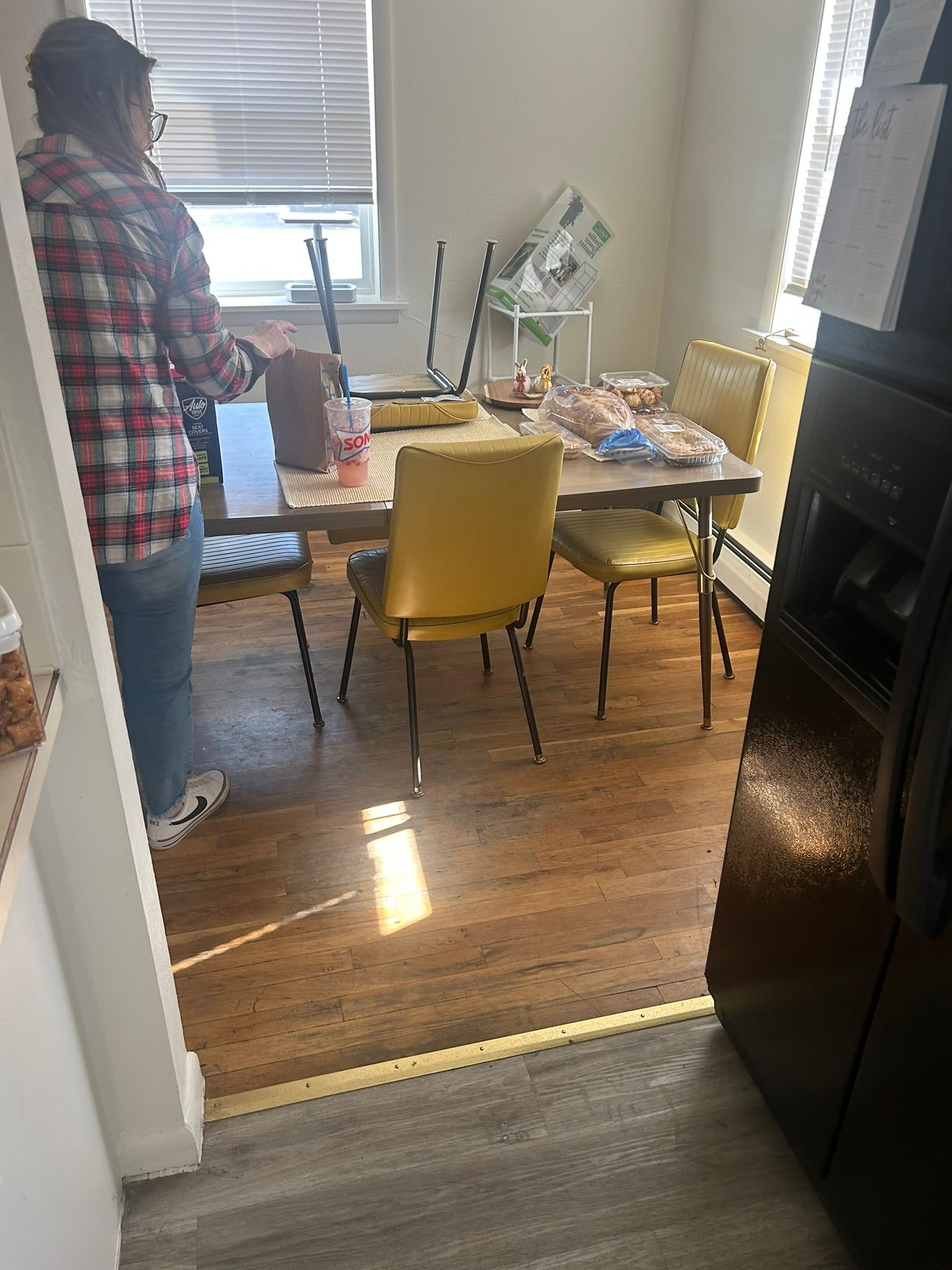 A man is standing in a dining room next to a table and chairs.