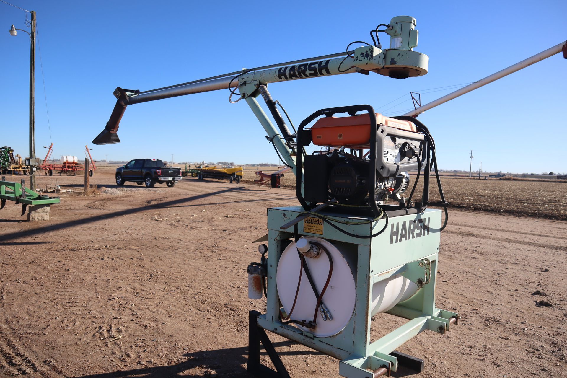 A harsk machine is parked in a dirt field