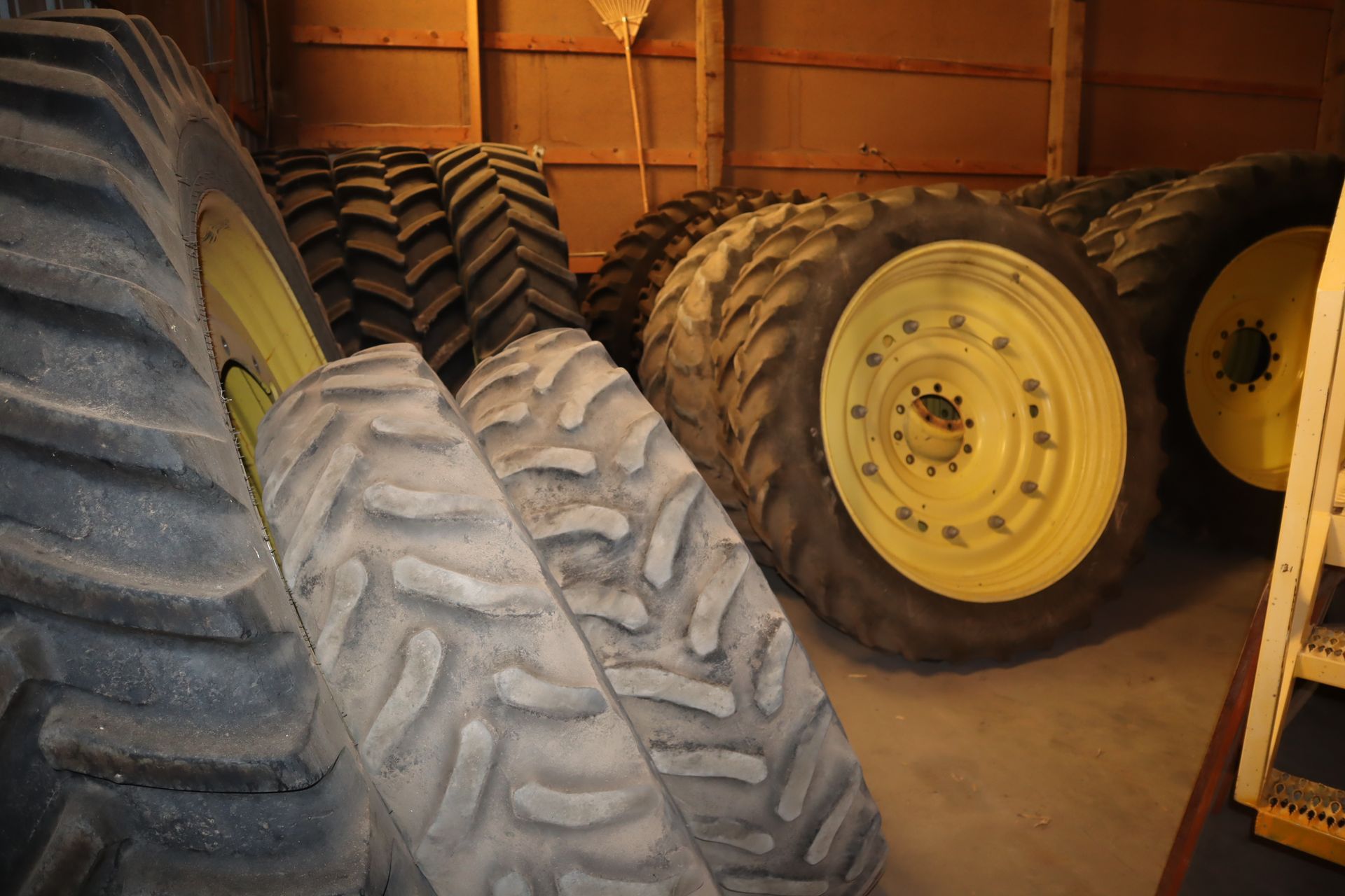 A bunch of tires are stacked on top of each other in a garage.