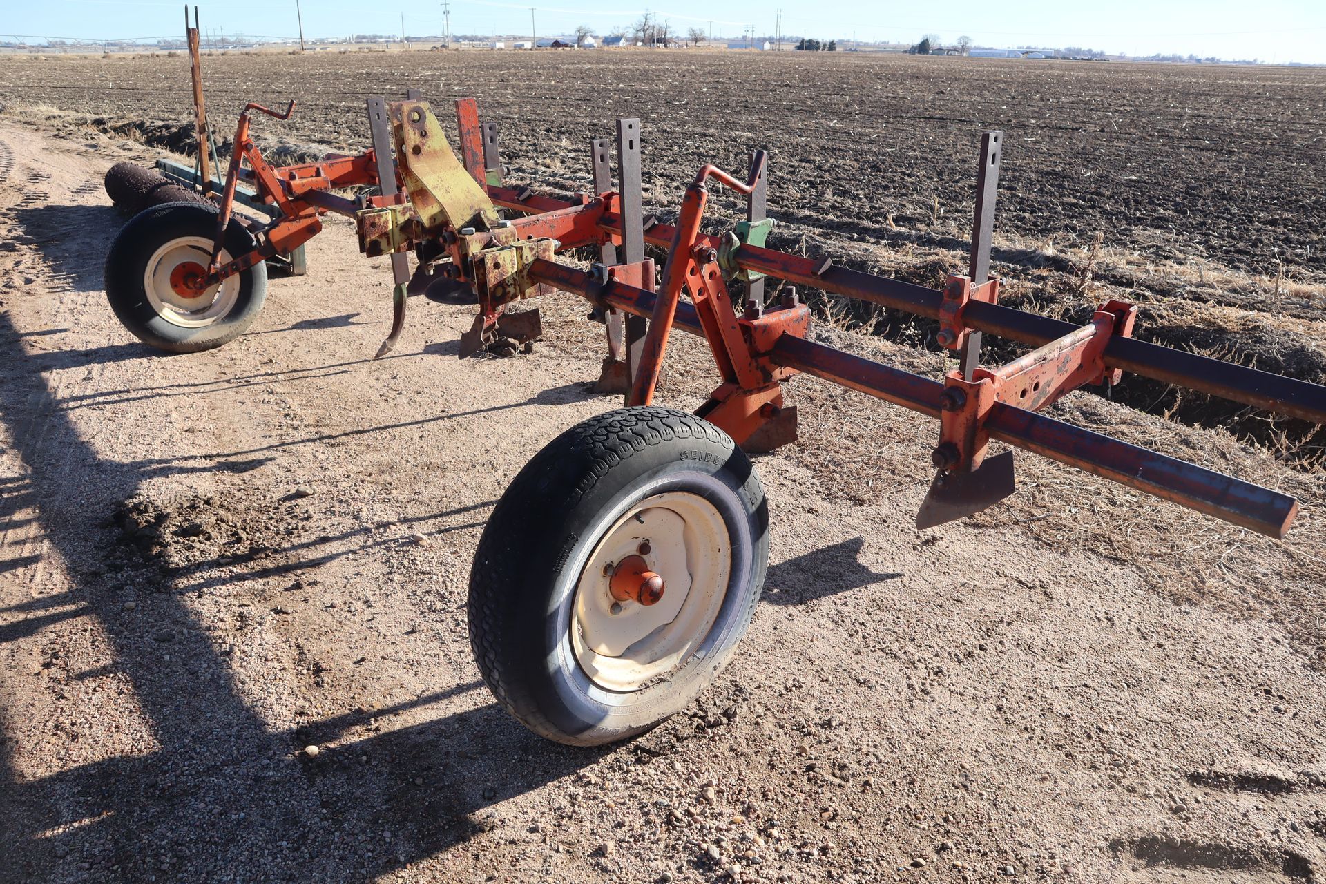 A tractor is parked in the middle of a dirt field