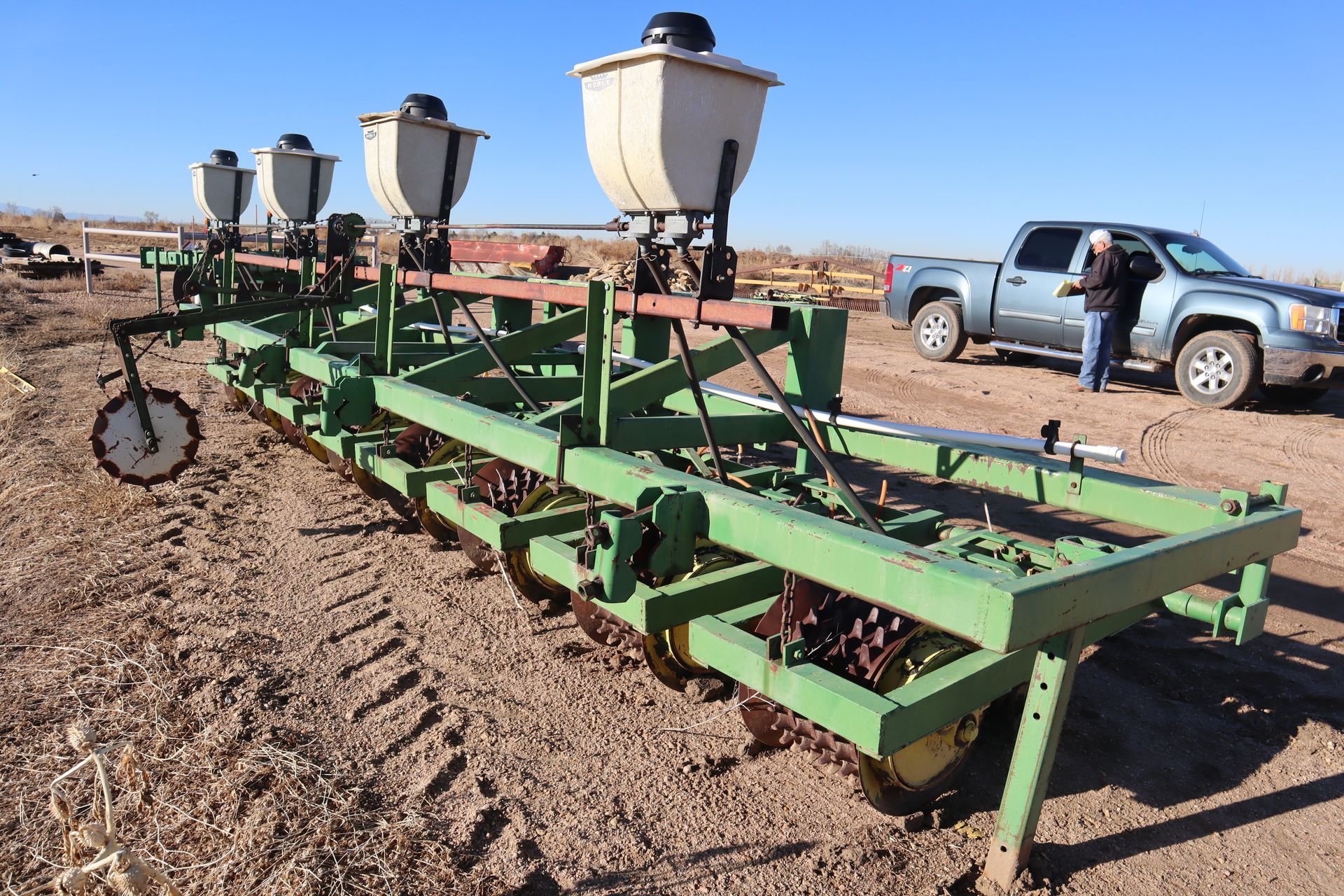 A man is standing next to a tractor in a field.