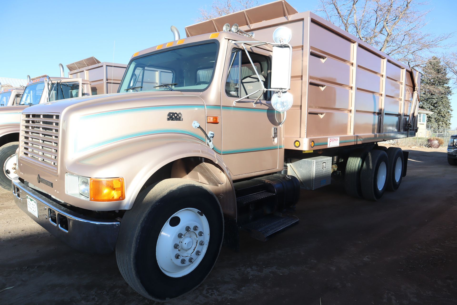 A truck with a trailer attached to it is parked in a parking lot.
