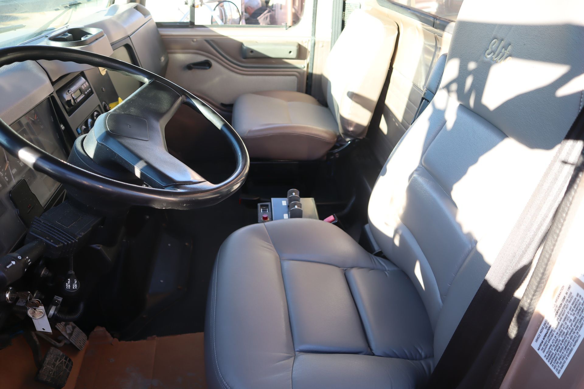 The interior of a truck with a steering wheel and seats