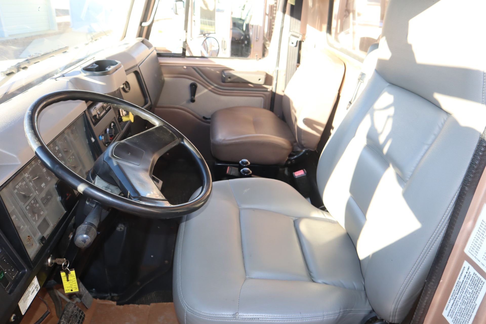 The interior of a truck with a steering wheel and seats.