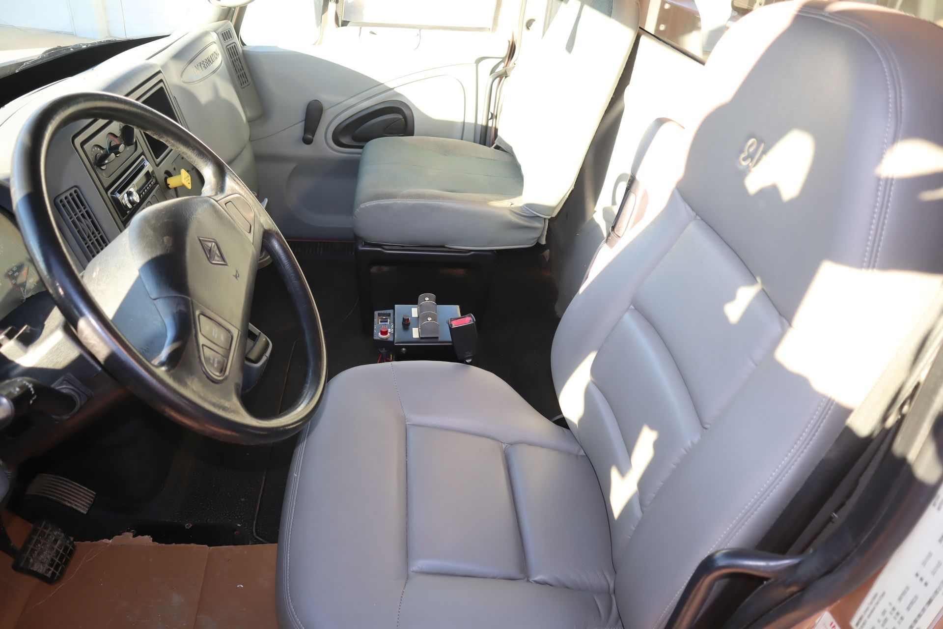 The interior of a truck with a steering wheel and seats