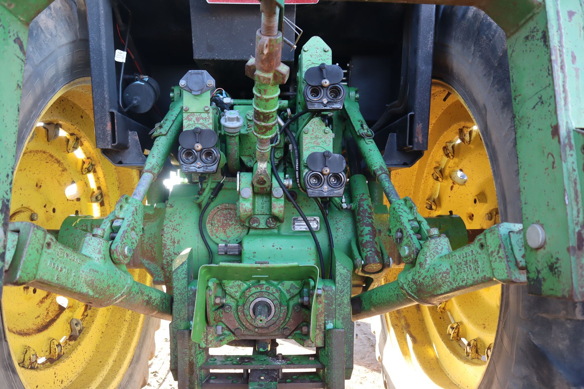 The rear end of a green and yellow john deere tractor