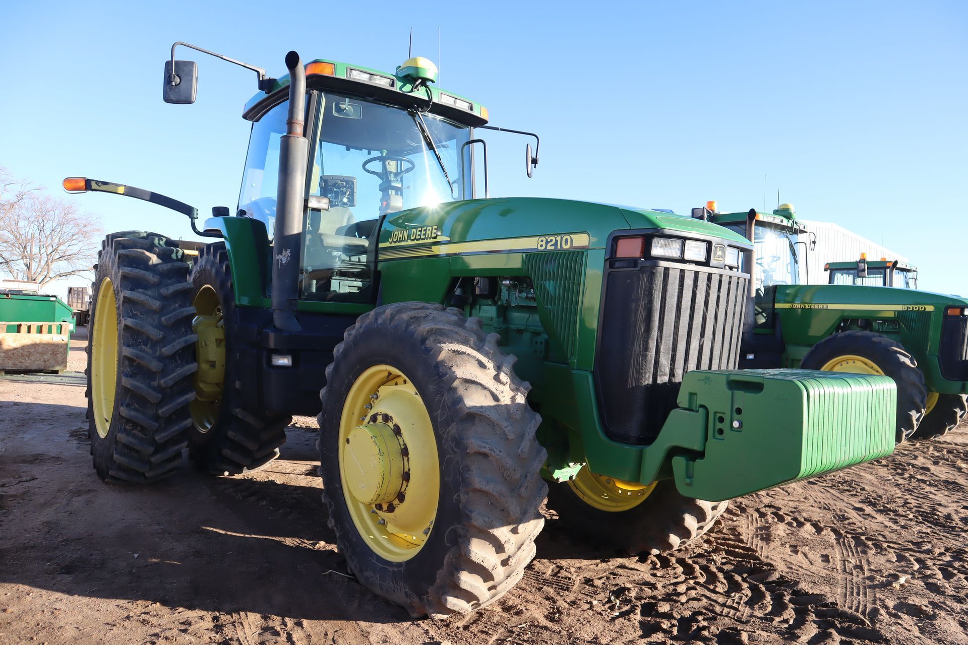 A john deere tractor is parked in a dirt field