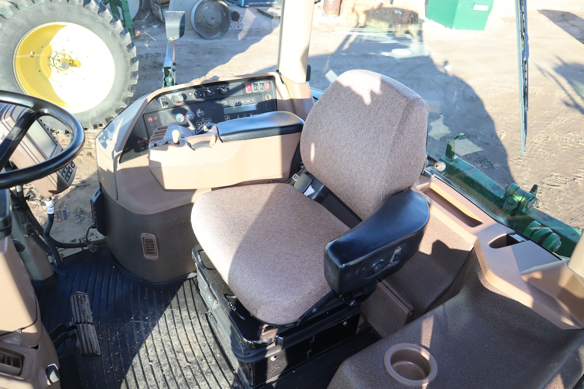 The inside of a tractor with a seat and steering wheel