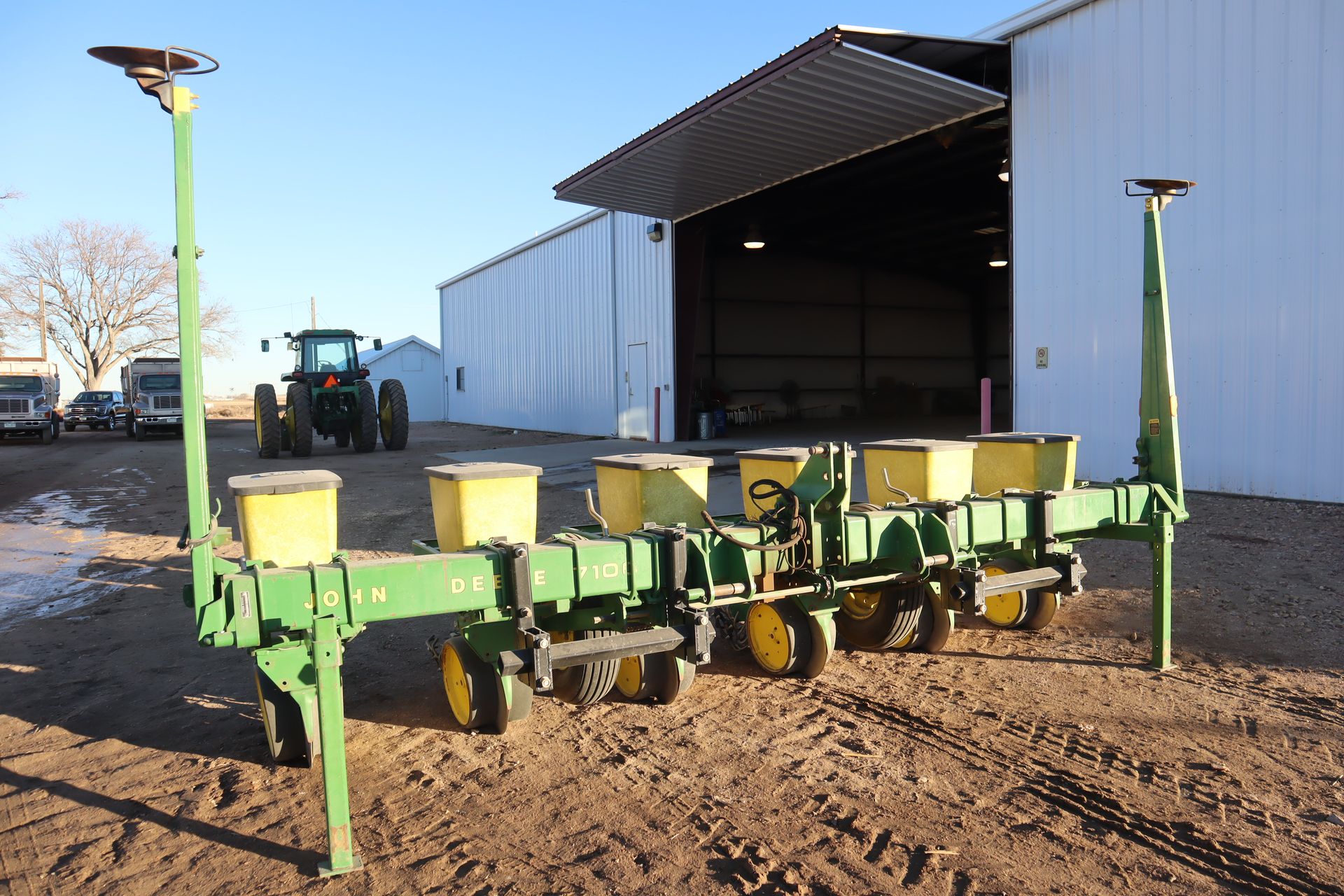 A john deere planter is parked in front of a building