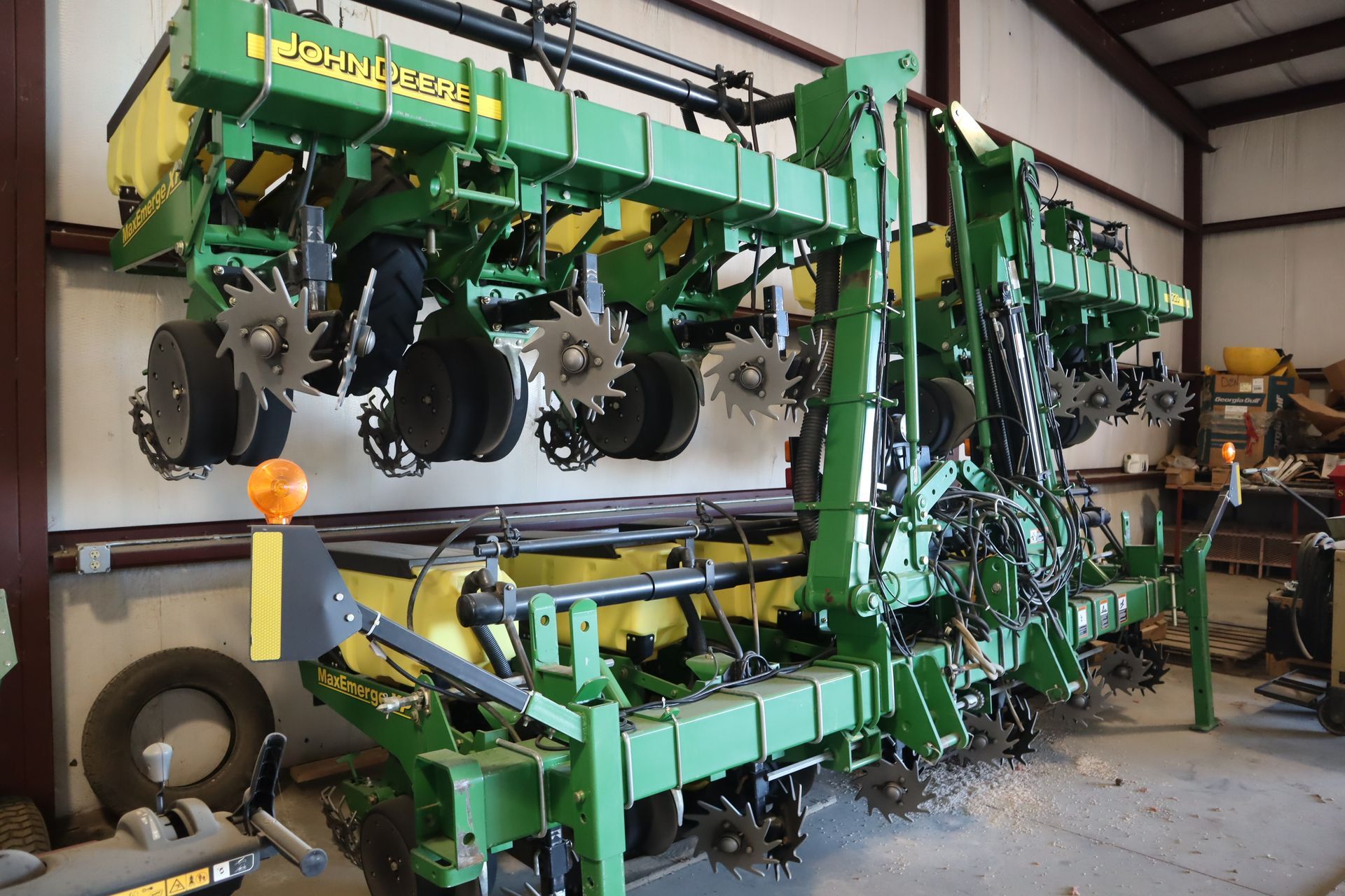 A john deere planter is sitting in a warehouse